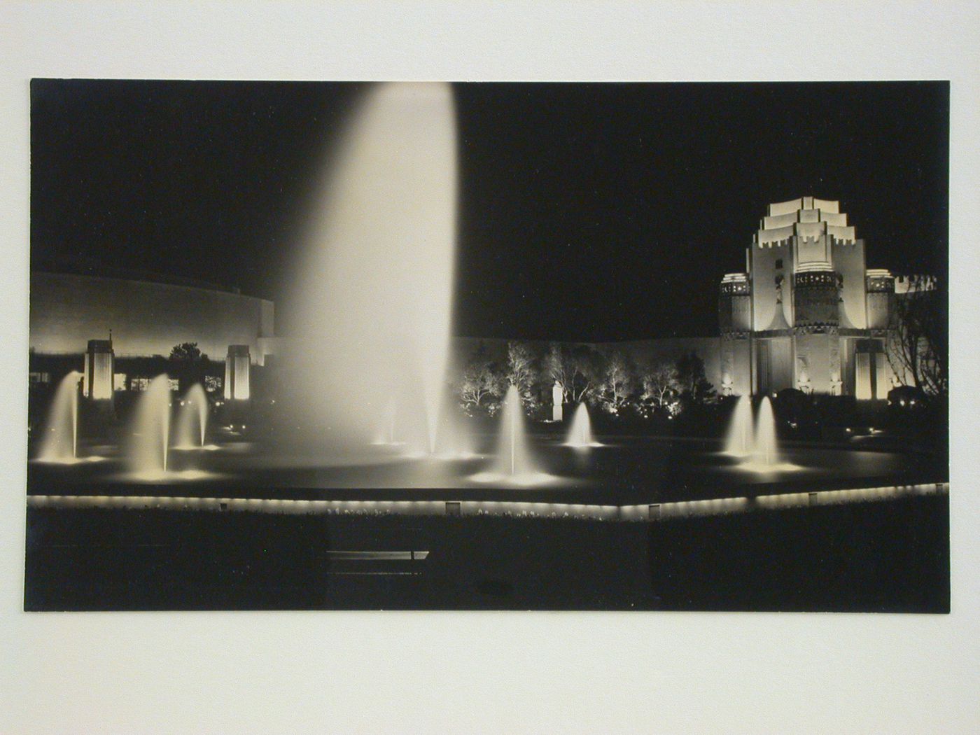 Night view of the fountain in the Treasure Garden with partial views of the Administration and Mines, Metals and Machinery buildings, Golden Gate International Exposition of 1939-1940, Treasure Island, San Francisco, California