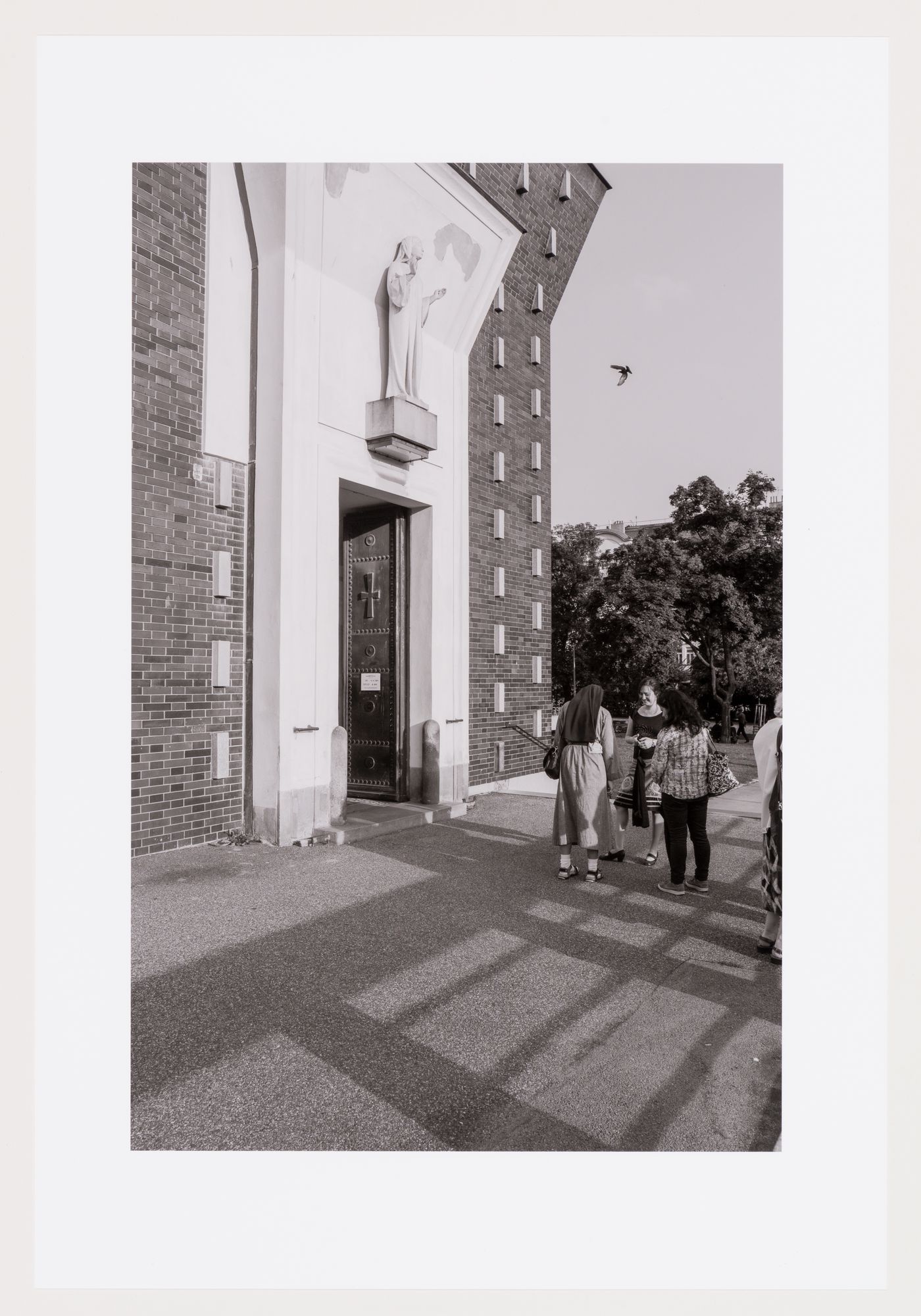 People at exterior entrance, the Church of the Sacred Heart of the Lord, Vinohardy, Prague