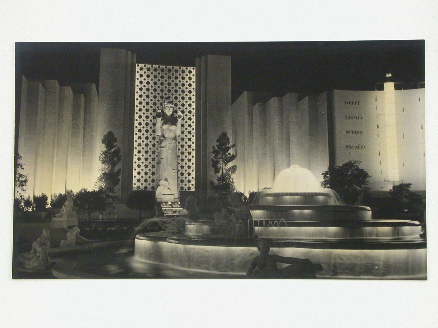 Night view of the Court of Pacifica showing the statue of Pacifica with partial views of the Fountain of Western Waters and General Motors and Ford Buildings, Golden Gate International Exposition of 1939-1940, Treasure Island, San Francisco, California