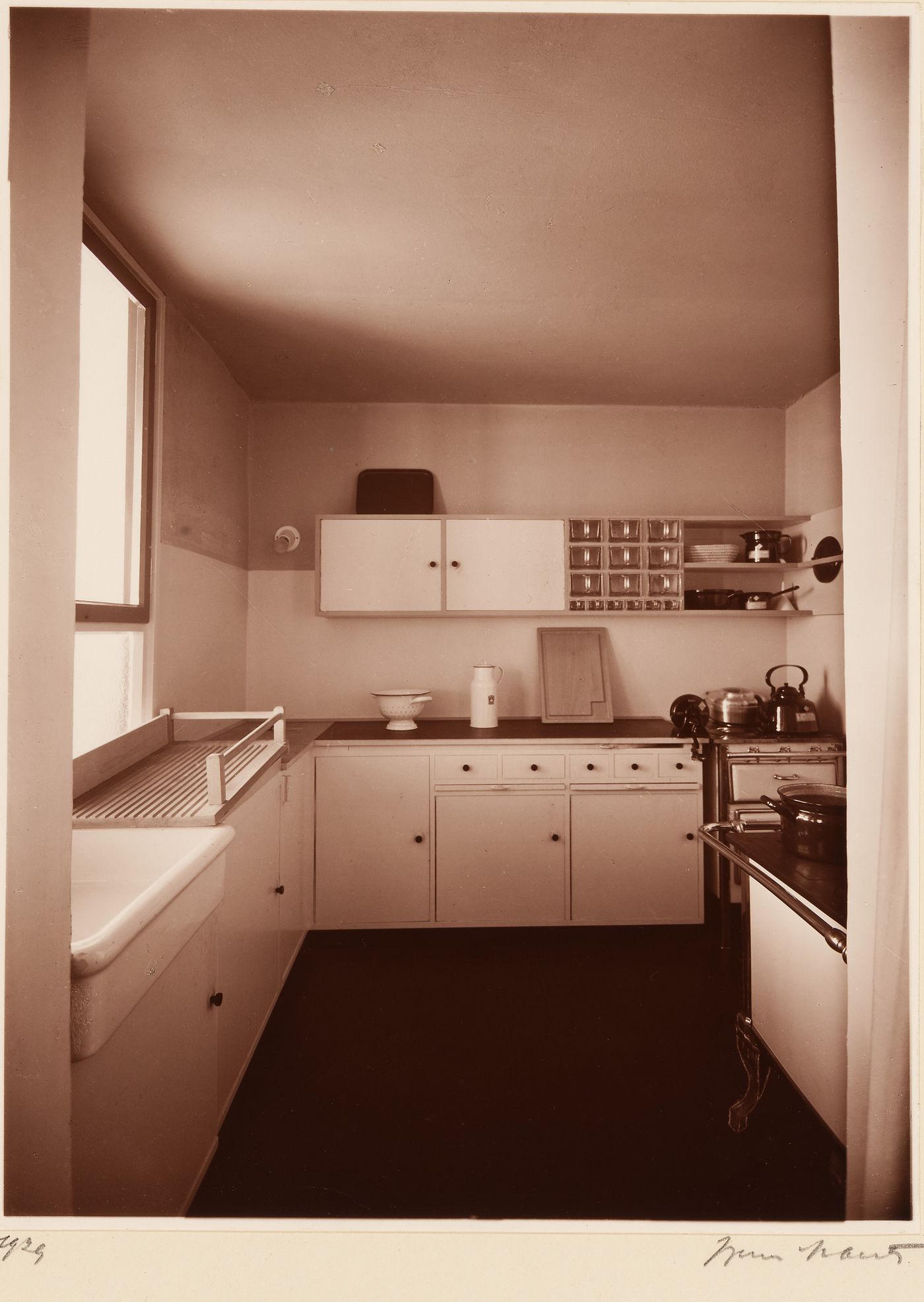 Interior, view of unidentified kitchen, illumination from window at left