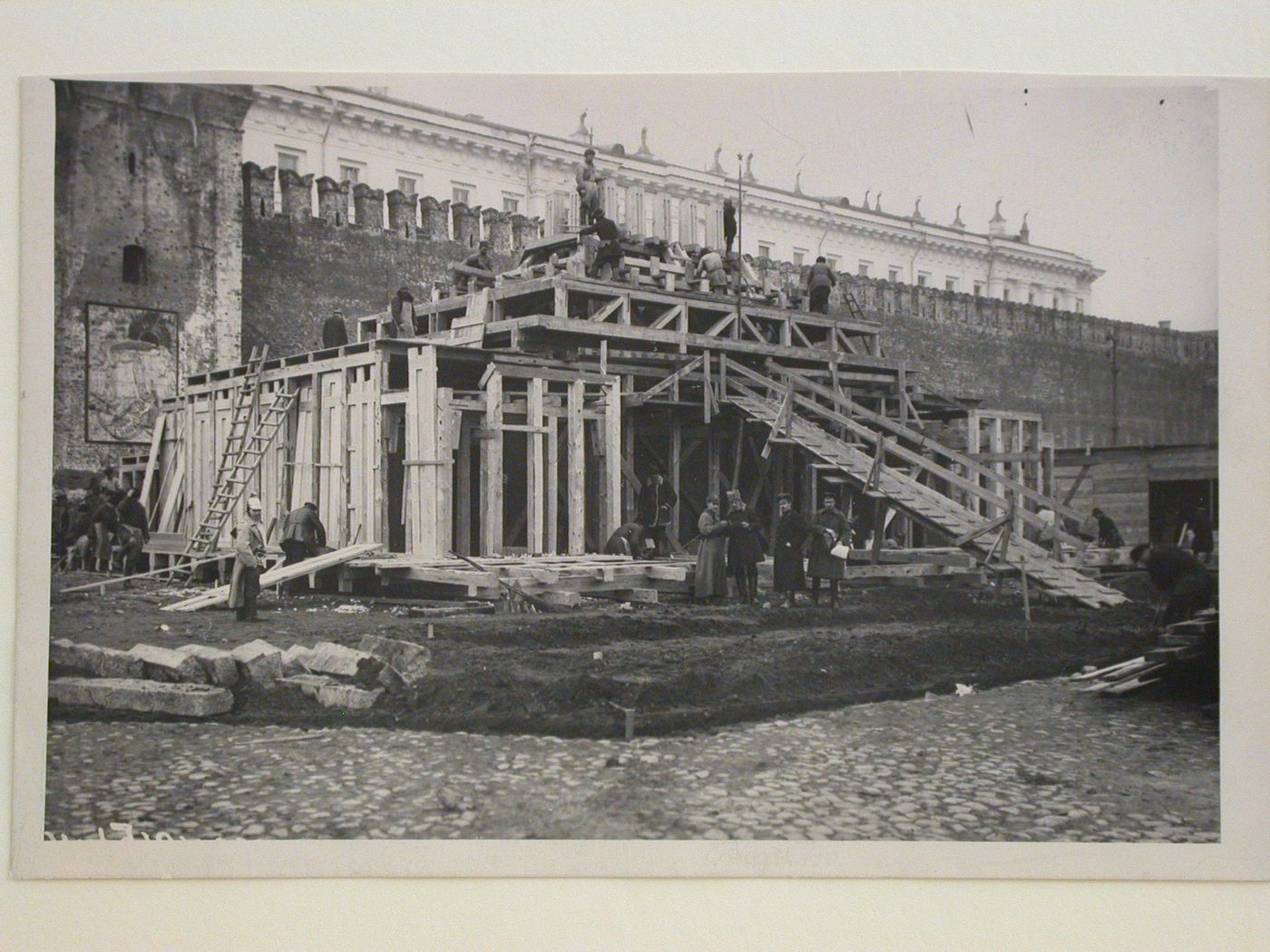 View of the second wooden Lenin Mausoleum under construction showing workers and officials, Red Square, Moscow