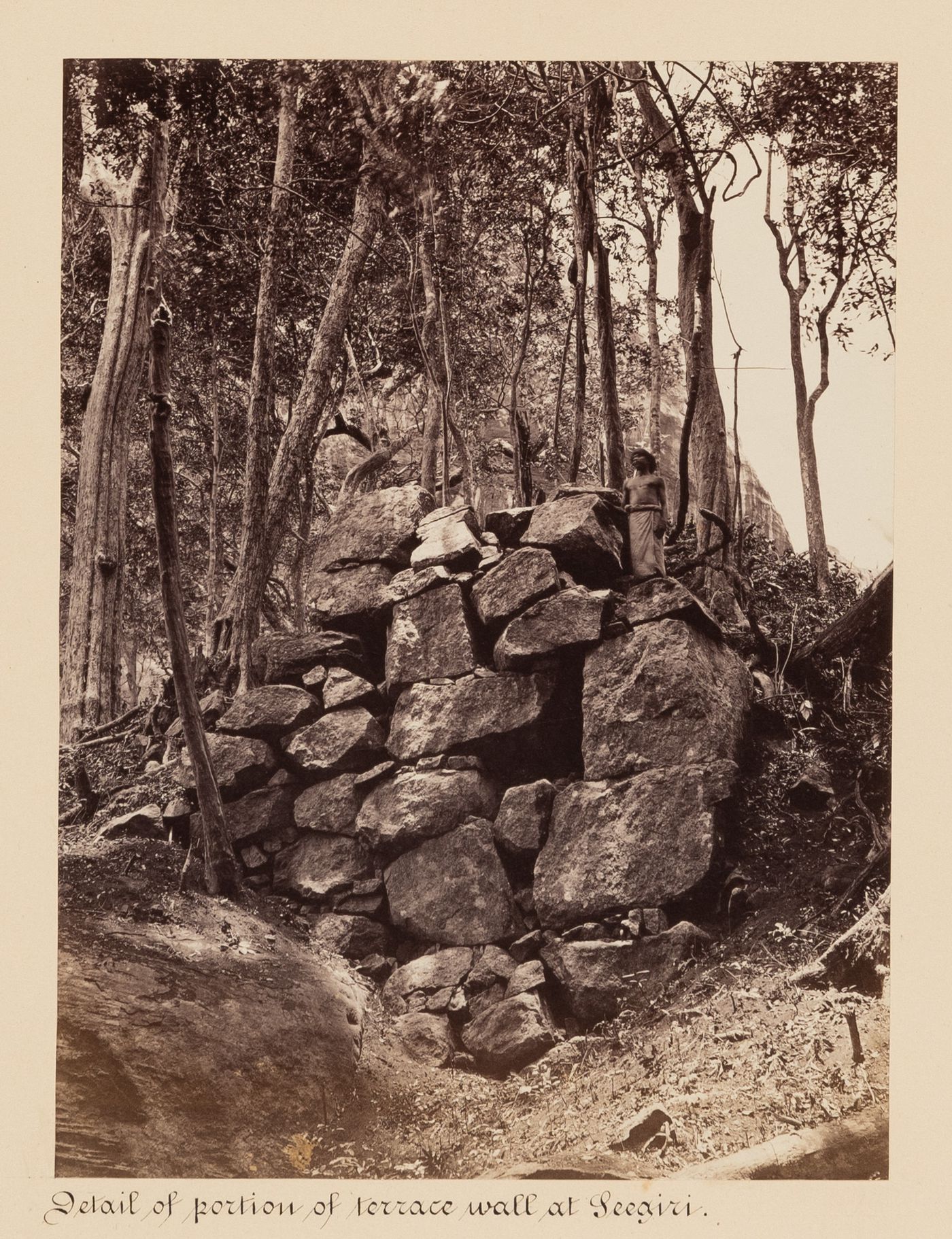 View of a wall with a man on top, Sigiriya, Ceylon (now Sri Lanka)