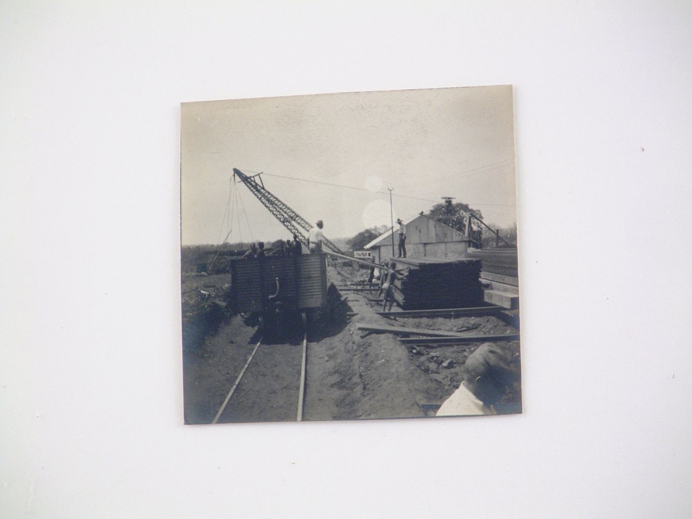 View of people loading wooden railway sleepers onto rail car with crane for the construction of Victoria Falls Bridge, Zambezi River, crossing the border between Victoria Falls, Zimbabwe and Livingstone, Zambia