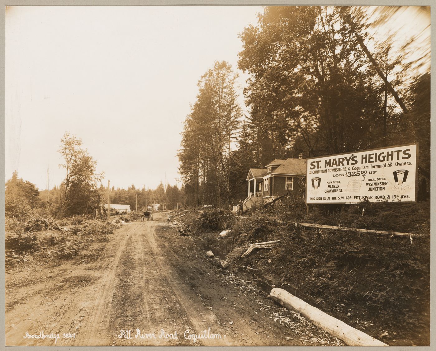 View of Pitt River Road showing St. Mary's Heights housing development (now Mary Hill) with a model house [?] on the right, Coquitlam (now Port Coquitlam), British Columbia