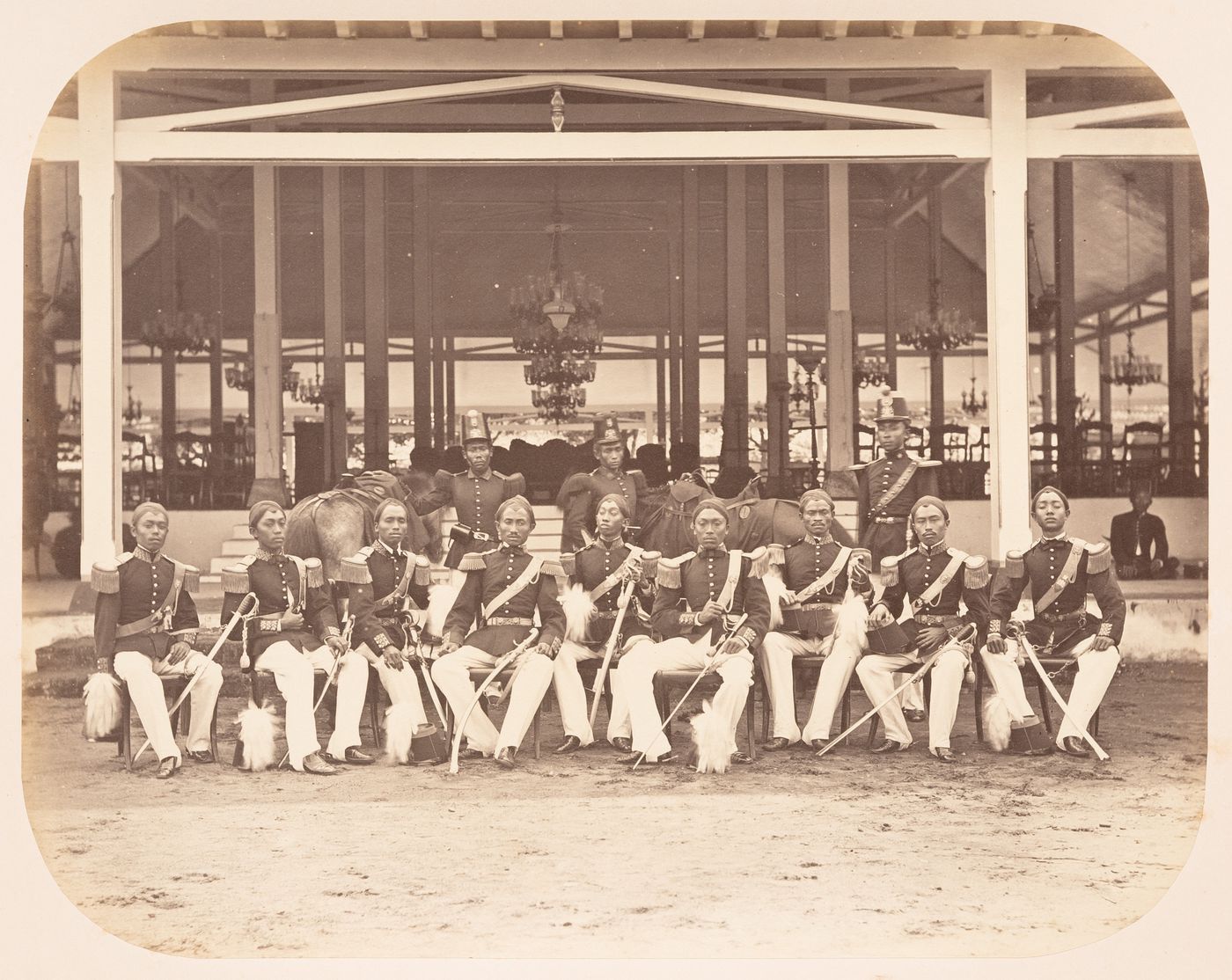 Group portrait of officials of Prince Mangkunegoro IV showing the pendopo of the Puro Mangkunegaran, Solo (now Surakarta), Dutch East Indies (now Indonesia)