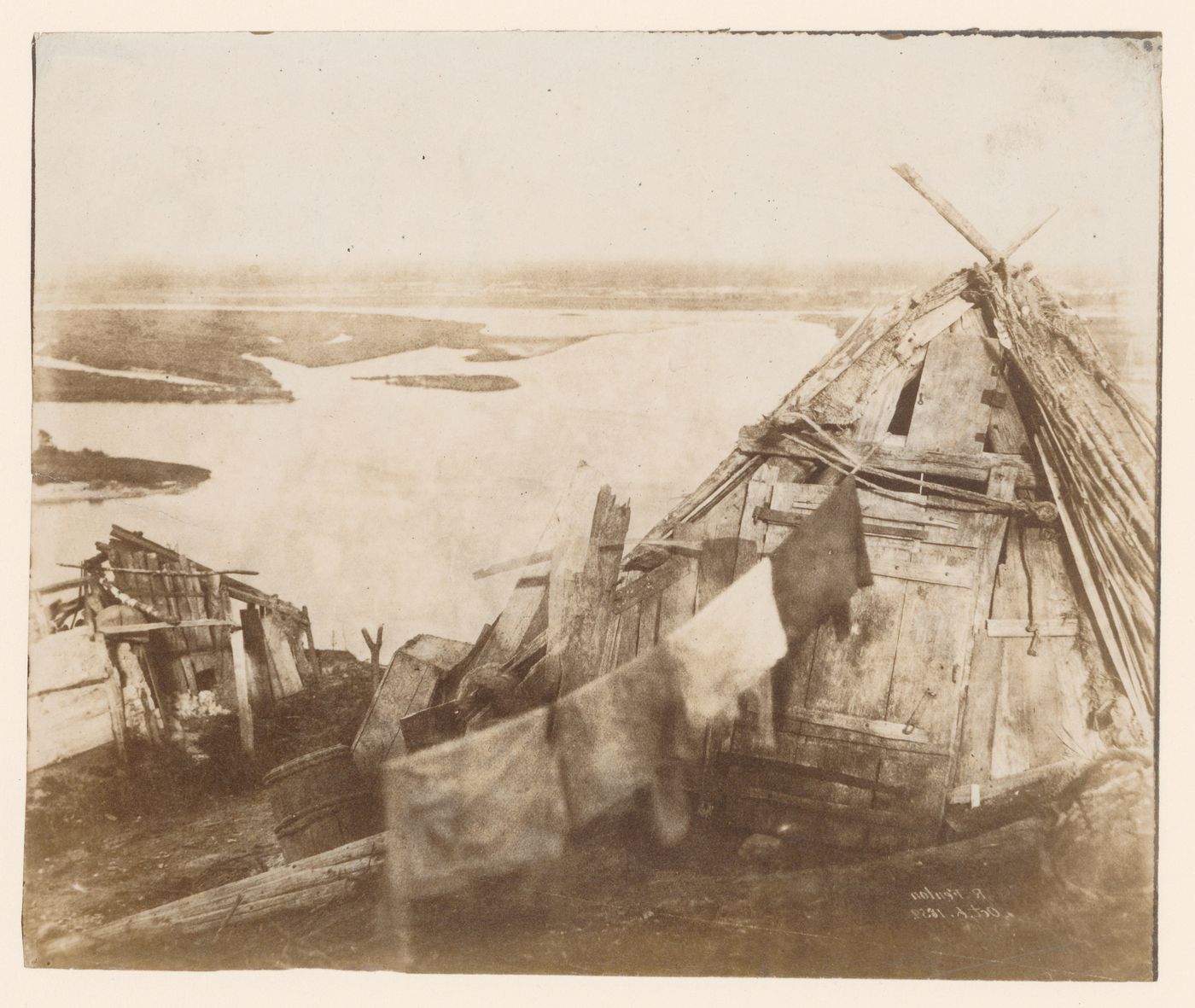 View of self-built wooden sheds with clothes line overlooking water (probably the Dnieper River) near Kiev, Russia (now Kyiv, Ukraine)
