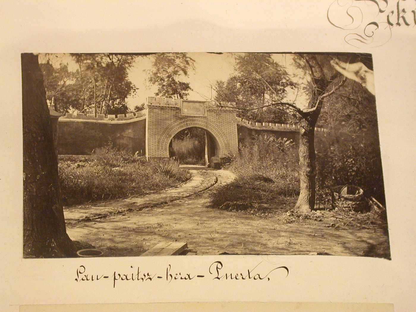 View of a gateway and wall with battlements in a garden [?], Peking (now Beijing), China