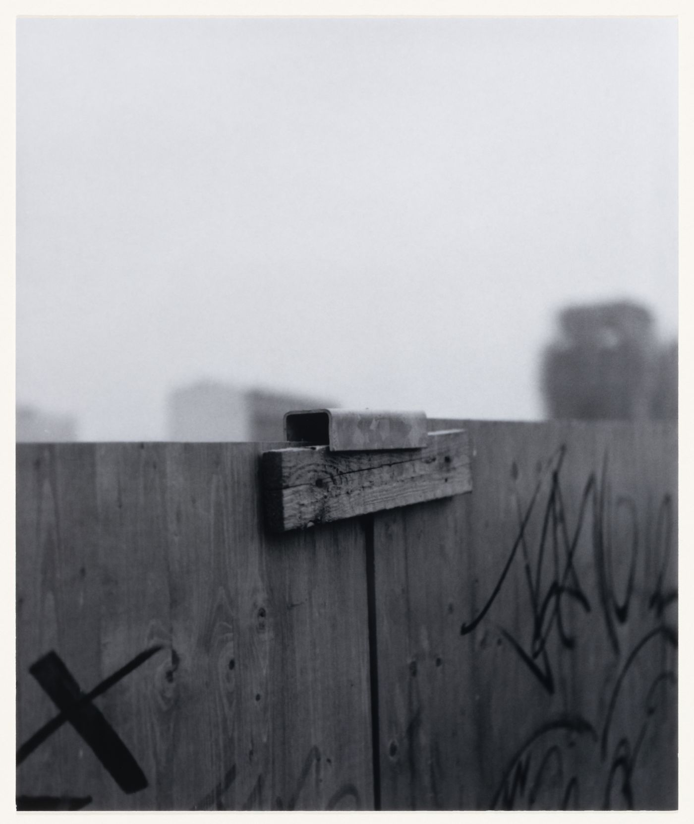 View of a wooden fence and graffiti showing buildings in the background, Berlin, Germany, from the artist book "The Potsdamer Project"