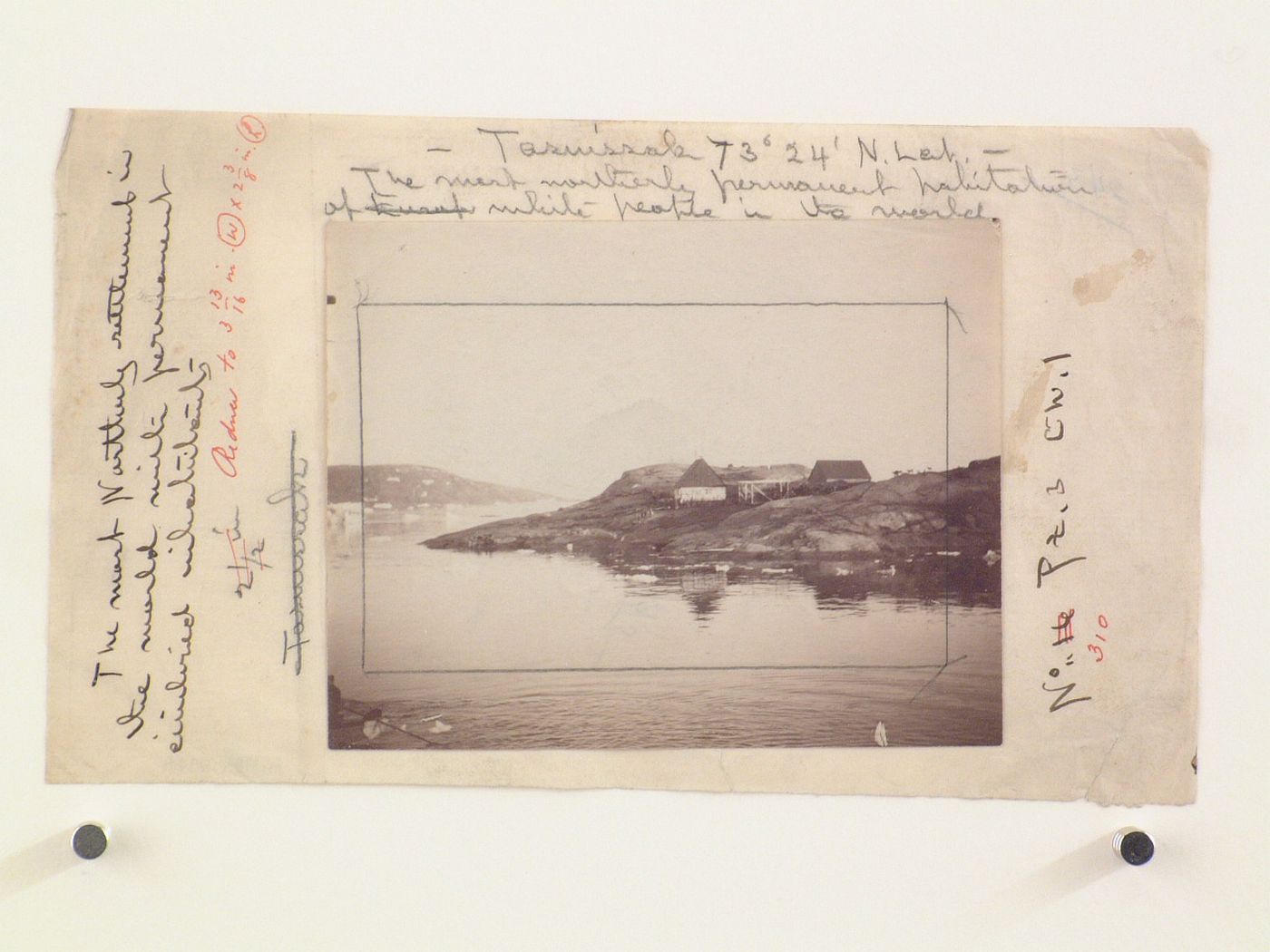 Distant view of houses, dock and figures on rocksby the water, Tasuissak, Greenland