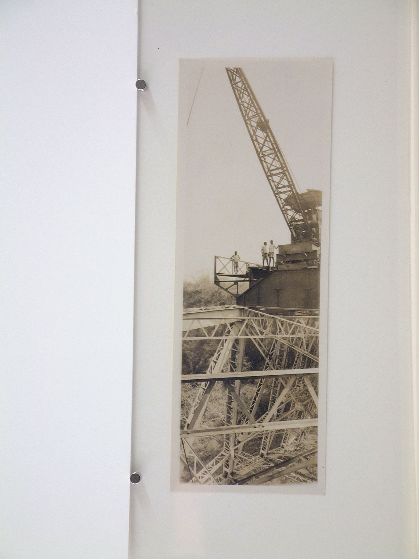 Vertical panoramic view of people standing by a crane during construction of the railway on Victoria Falls Bridge, Zambezi River, crossing the border between Victoria Falls, Zimbabwe and Livingstone, Zambia