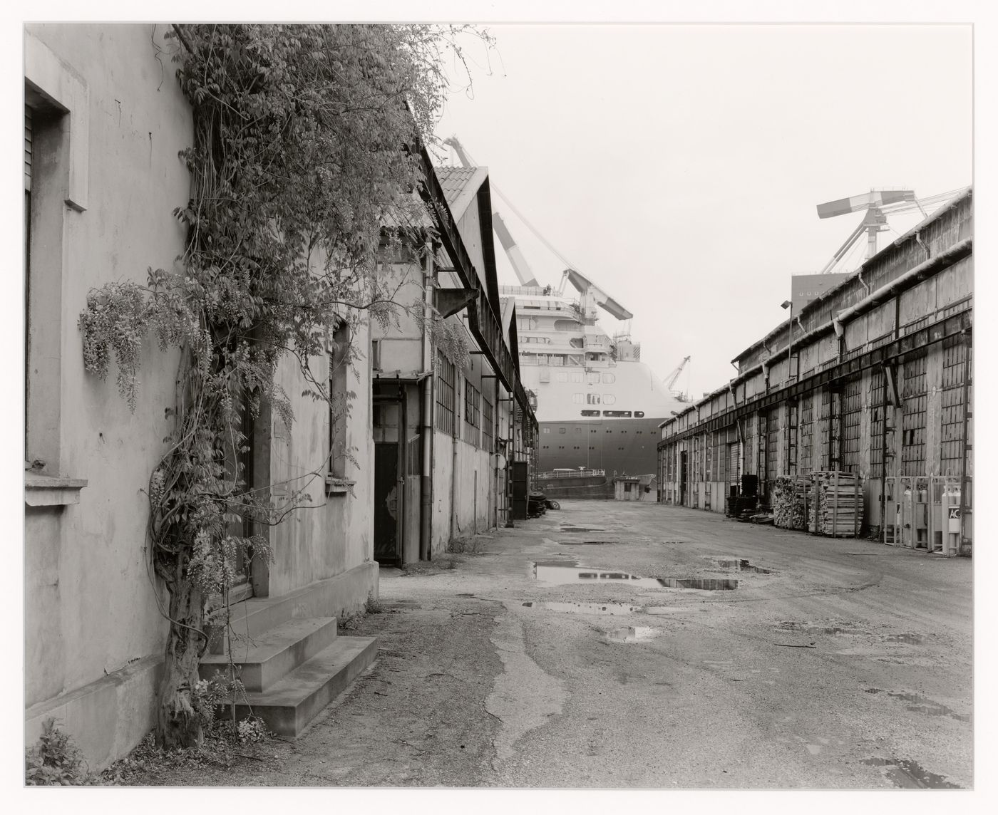 View of an alley and buildings with a ship in the background, Marghera, Italy