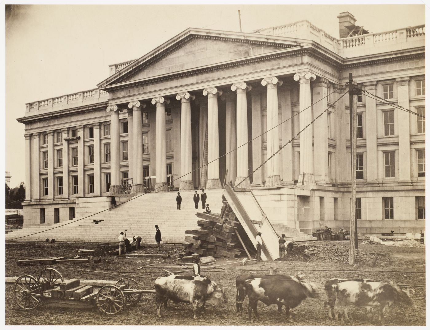 Treasury Building under contruction: Term of oxen pulling cart, team of men hoisting wooden platform, figures watching from steps, Washington, District of Columbia
