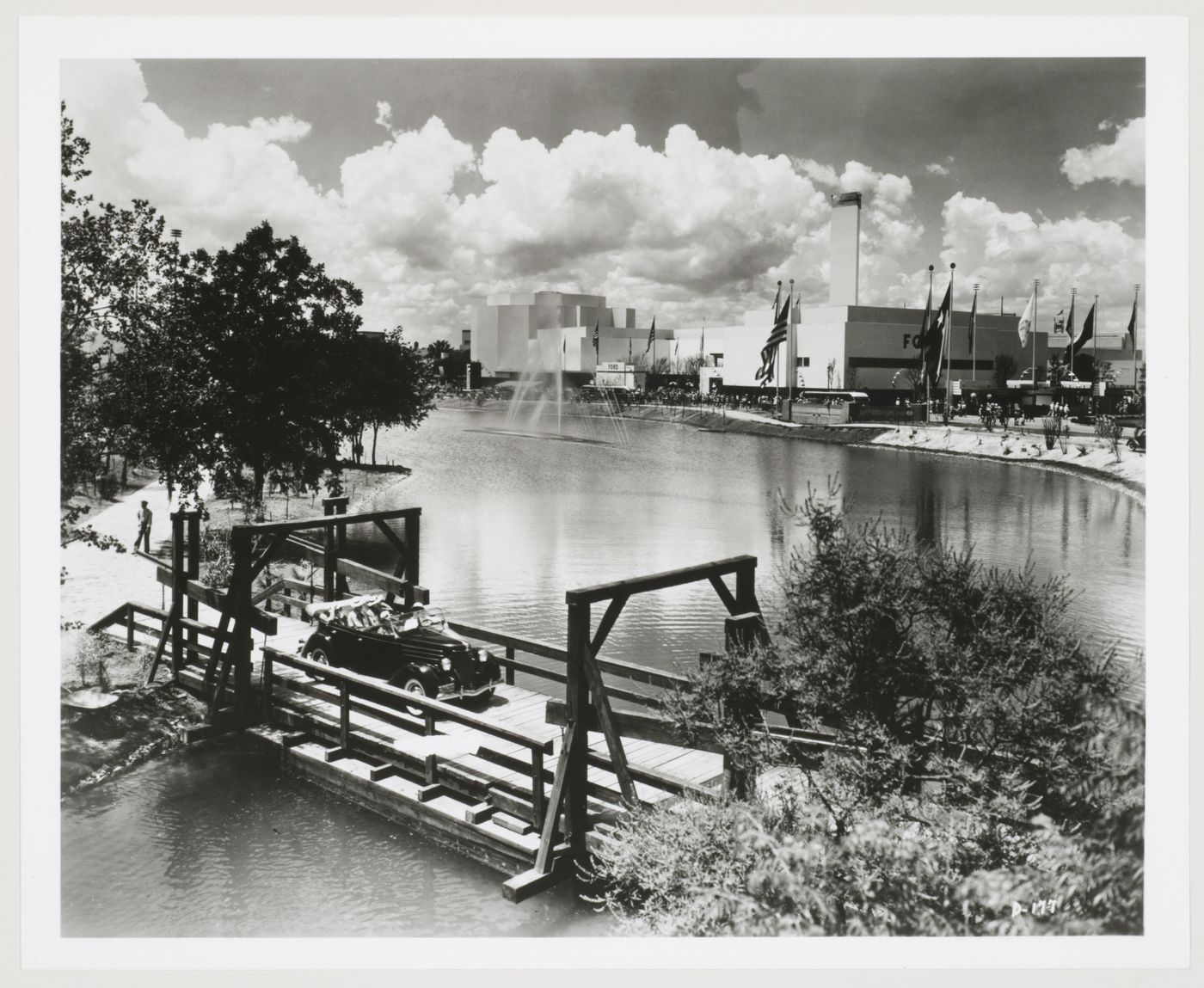 View of the Ford Motor Company pavilion from across a river showing an automobile and fountain, 1939-1940 New York World's Fair, New York City, New York