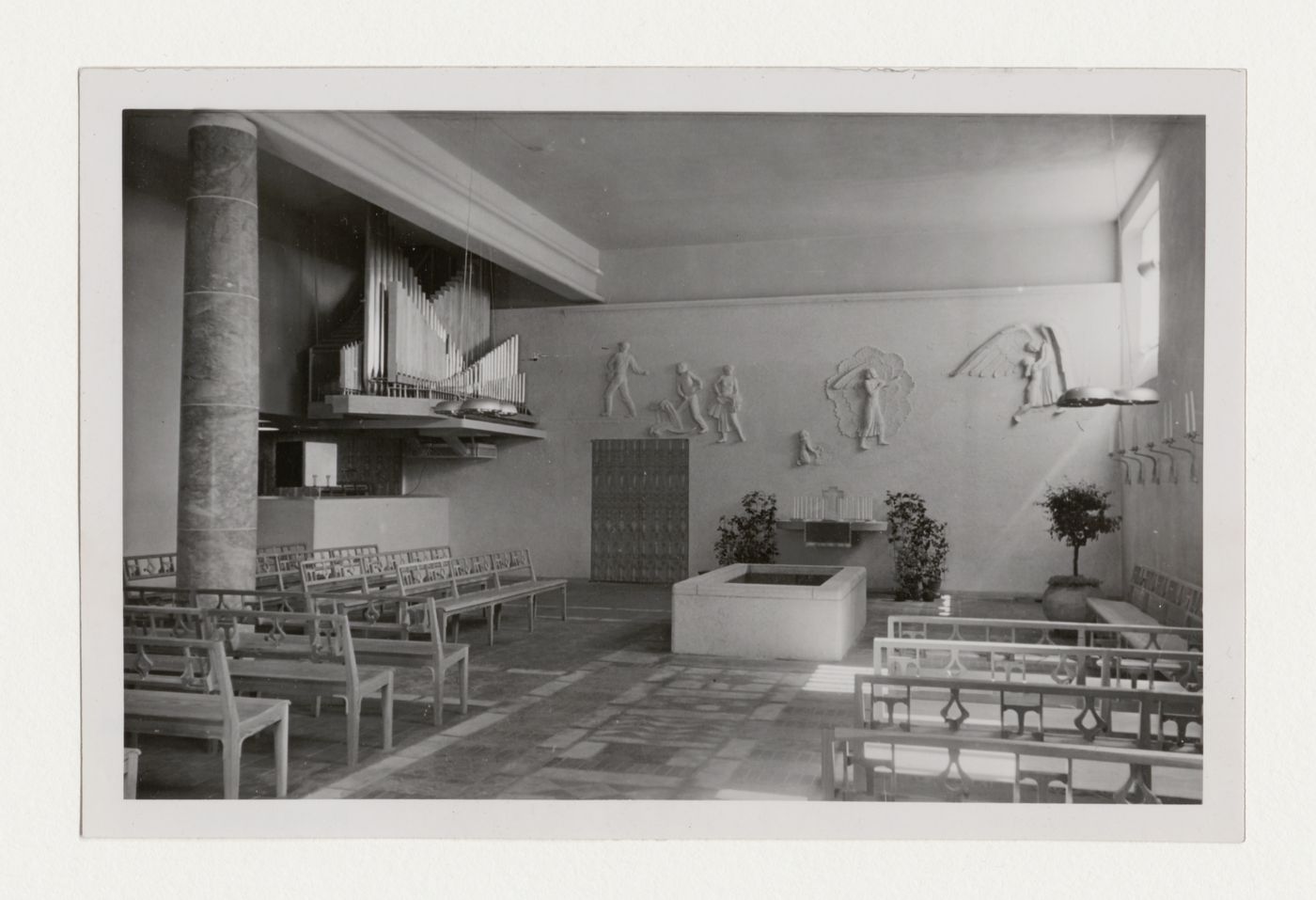Interior view of the Chapel of Faith showing pews, organ pipes and the wall relief designed by Ivar Viktor Johnsson, Woodland Crematorium and Cemetery, Stockholm