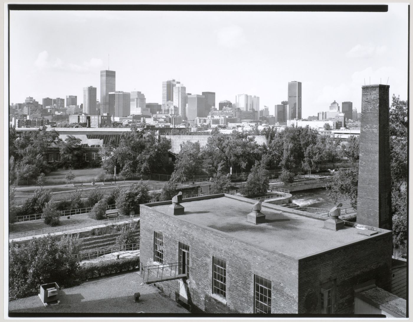 View of Lachine Canal and the Caledonian Ironworks Building looking north northwest from the roof of the Belding Corticelli Spinning Mill with downtown Montréal in the background, Québec