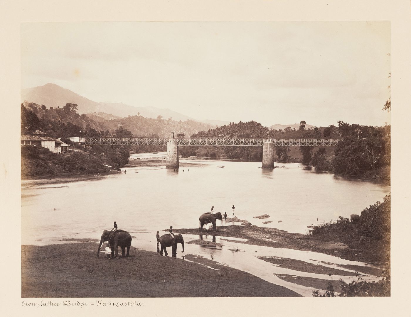 View of the Kutagastota Bridge over the Mahaweli Ganga with elephants and people in the foreground, Kutagastota, Ceylon (now Sri Lanka)