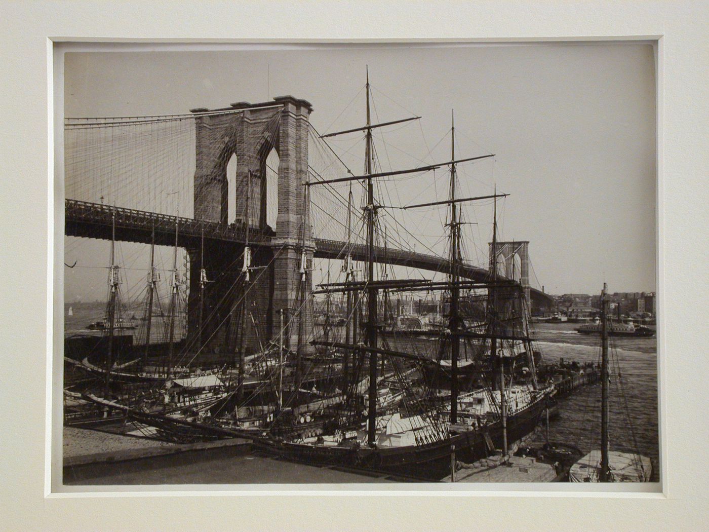 View of sailing vessels docked by the Brooklyn Bridge with the New York Tower in the foreground and the Brooklyn Tower in the background, New York City, New York, United States