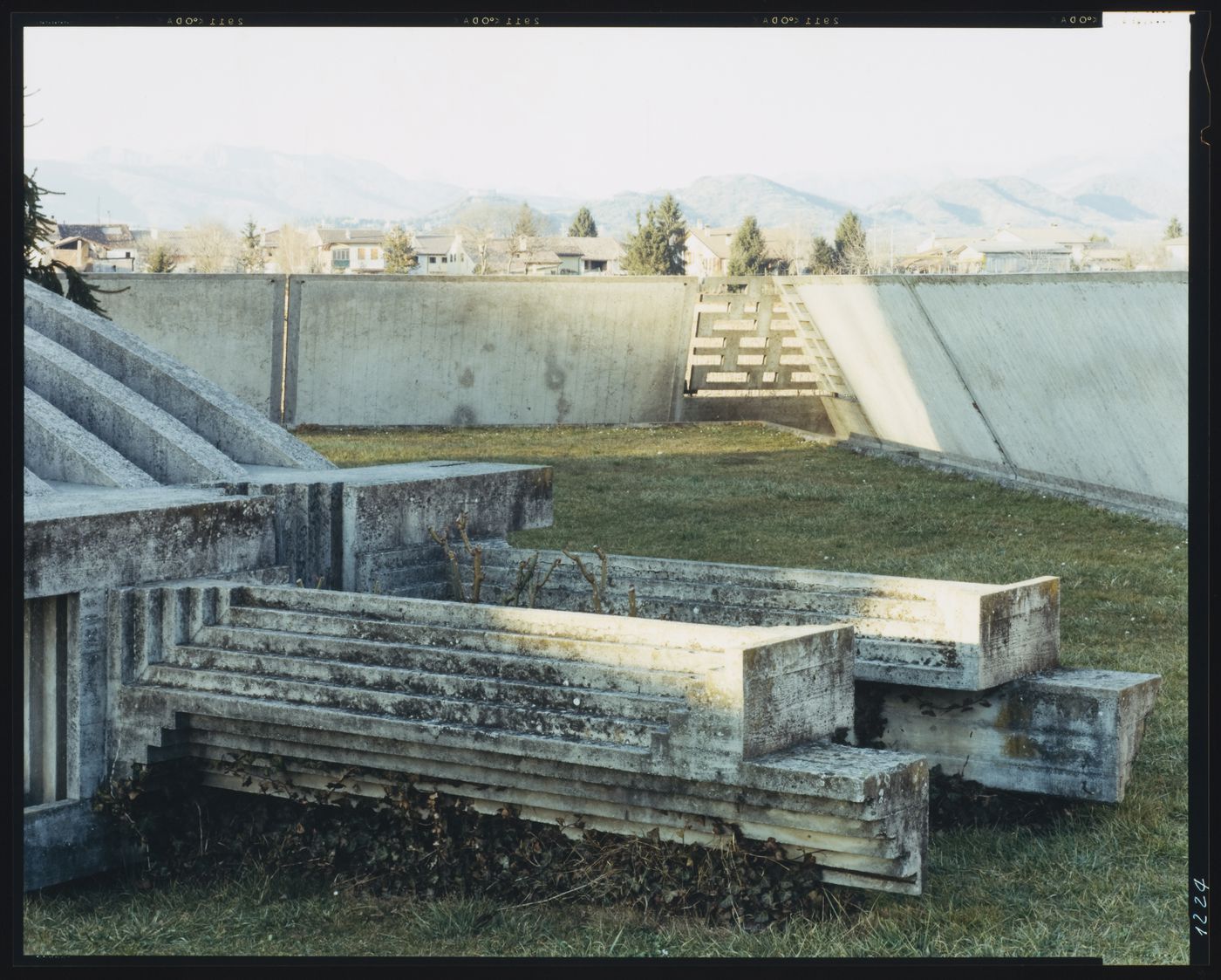 Partial view of the arcosolium with the perimeter wall, houses and hills in the background, Cimitero Brion, San Vito d'Altivole, near Asolo, Italy