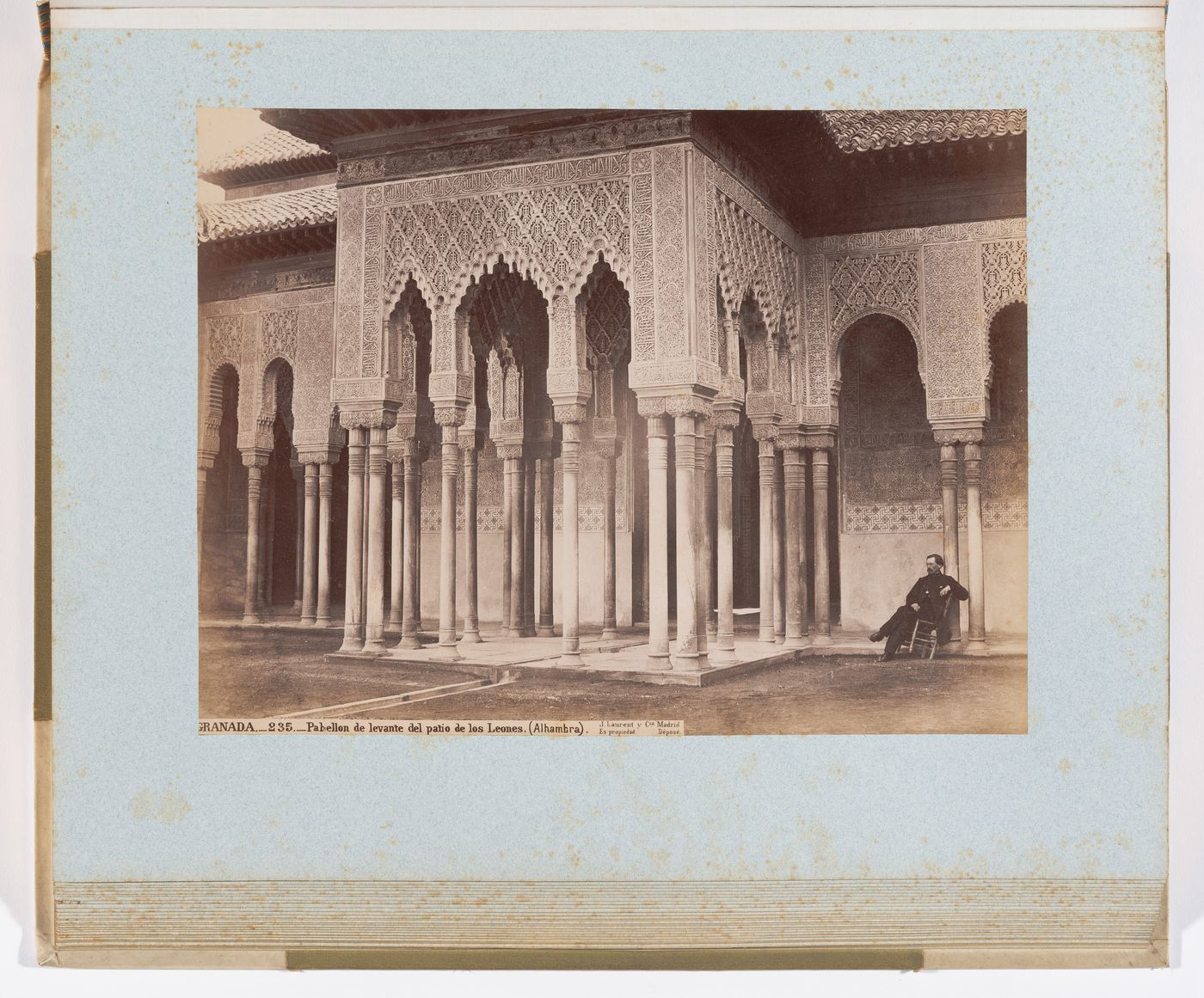 View of east pavilion with custodian sitting to the right of the pavilion, from center of the Court of the Lions, Alhambra, Granada, Spain
