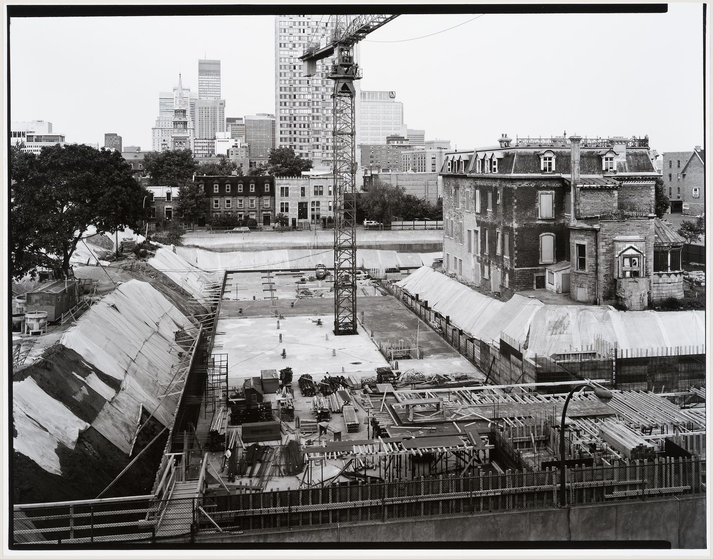 View of the construction site from the fifth floor of an apartment house on rue du Fort showing vault levels 1 and 2 with Shaughnessy House in the right background, Canadian Centre for Architecture under construction, Montréal, Québec