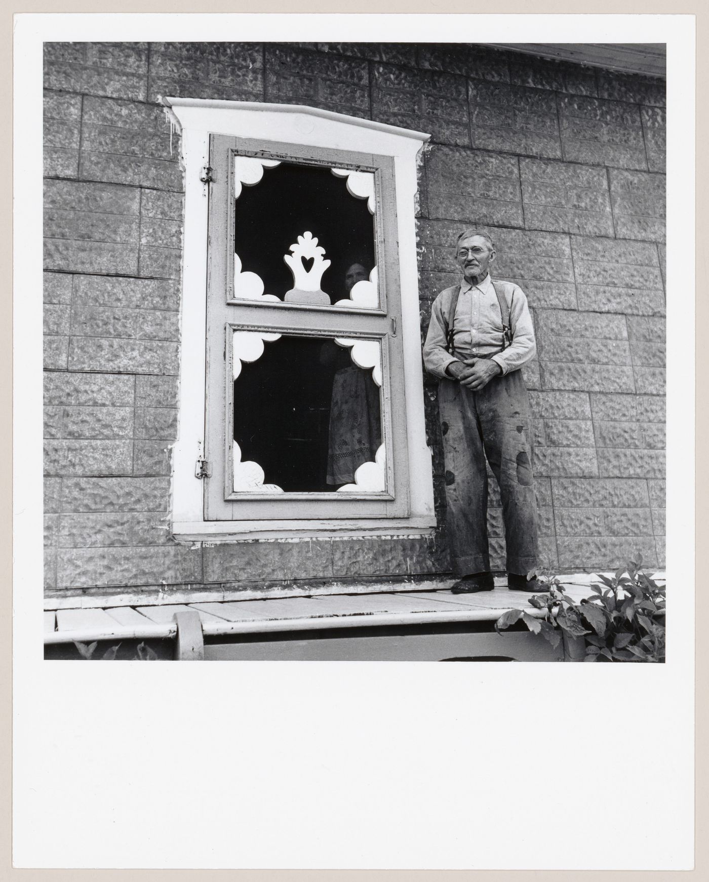 Germain Desmeules posant à côté de la porte-moustiquaire de sa maison, L'Isle-aux-Coudres, Charlevoix, Québec