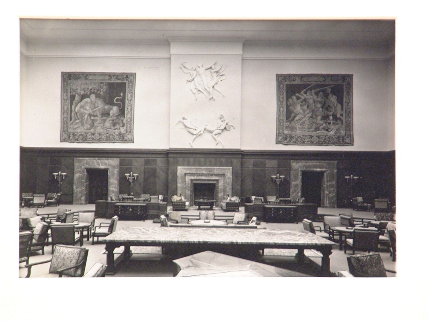 Interior of a large living room with tapestries, reliefs, marble fireplace, and much furniture, Munich, Germany