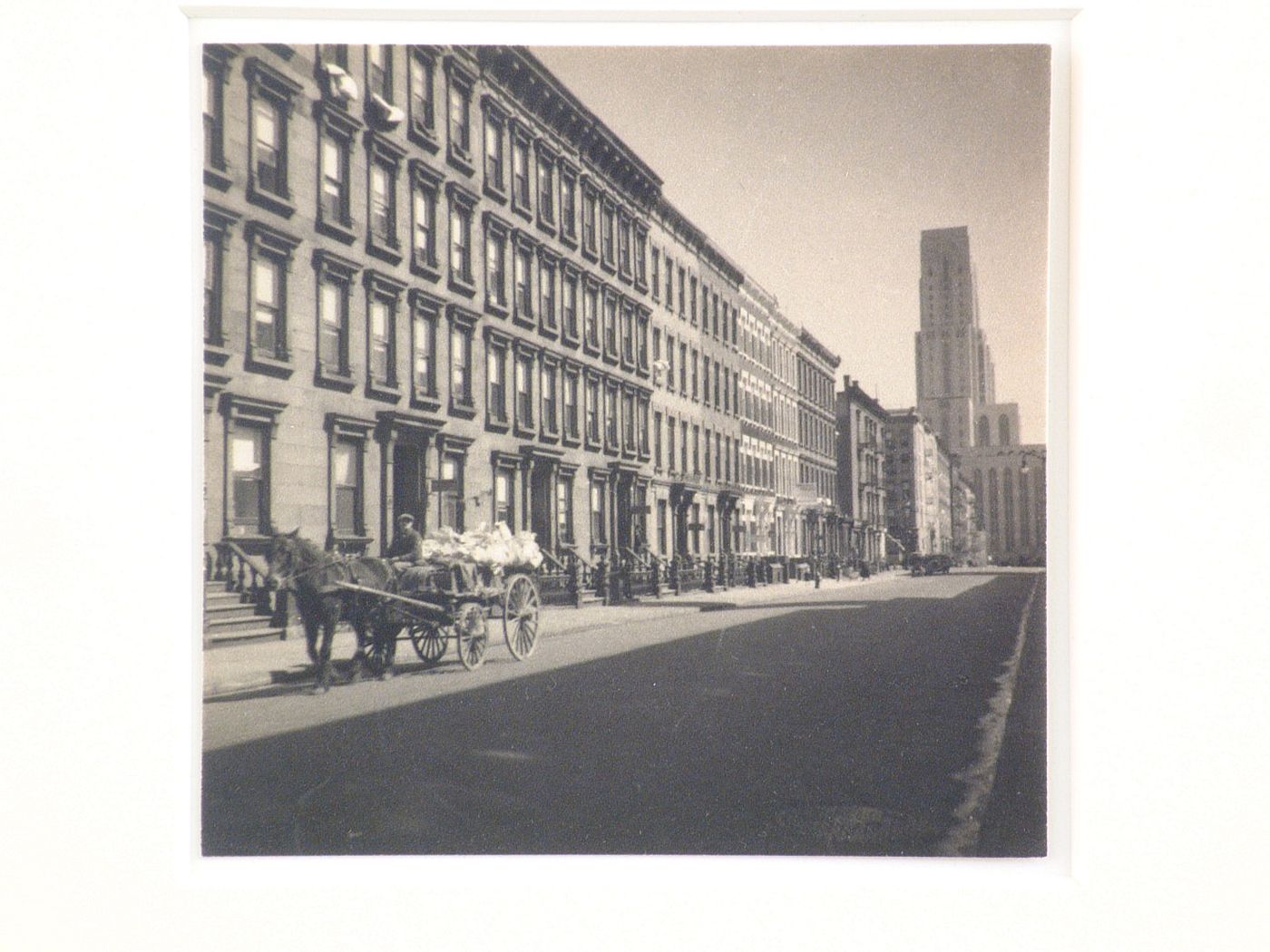 Rowhouses, horse & cart on street, Cornell Hospital at end of street, New York City, New York