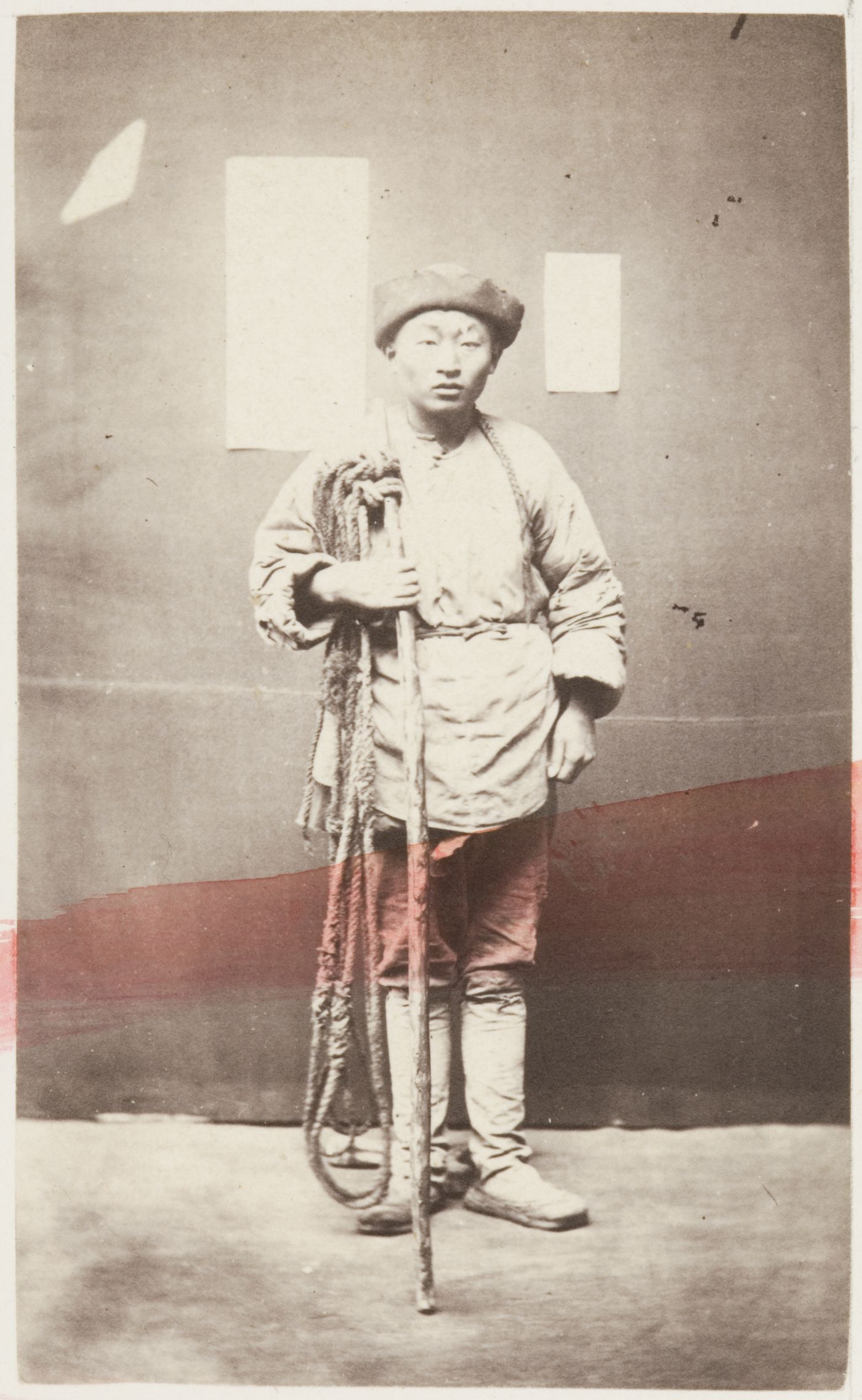 Portrait of a Chinese man porter ? holding a carrying pole