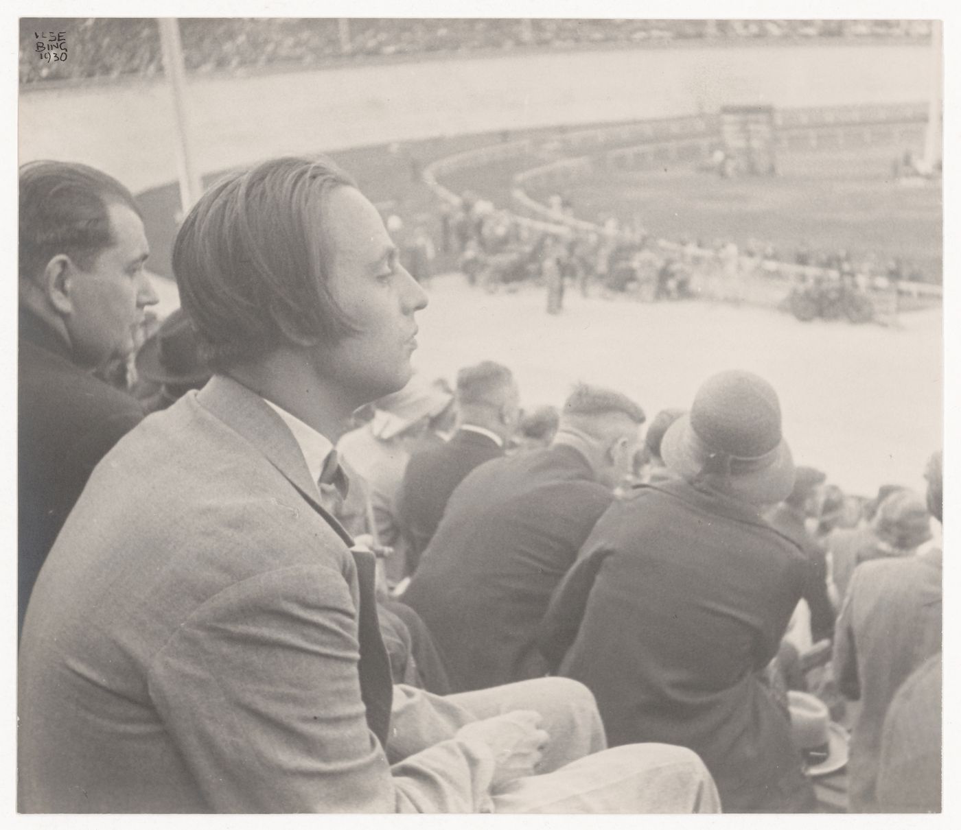 Portrait of Mart Stam sitting in the grandstands at a racetrack, Frankfurt am Main, Germany