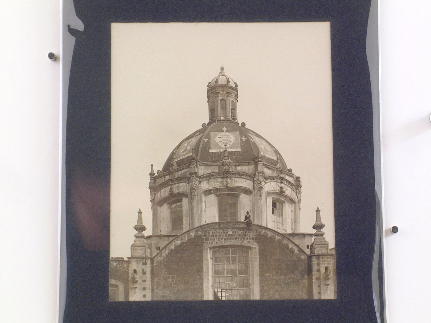 View of the dome of the Iglesia de la Santísima Trinidad with a man sitting on the ledge of a roof, Mexico City, Mexico