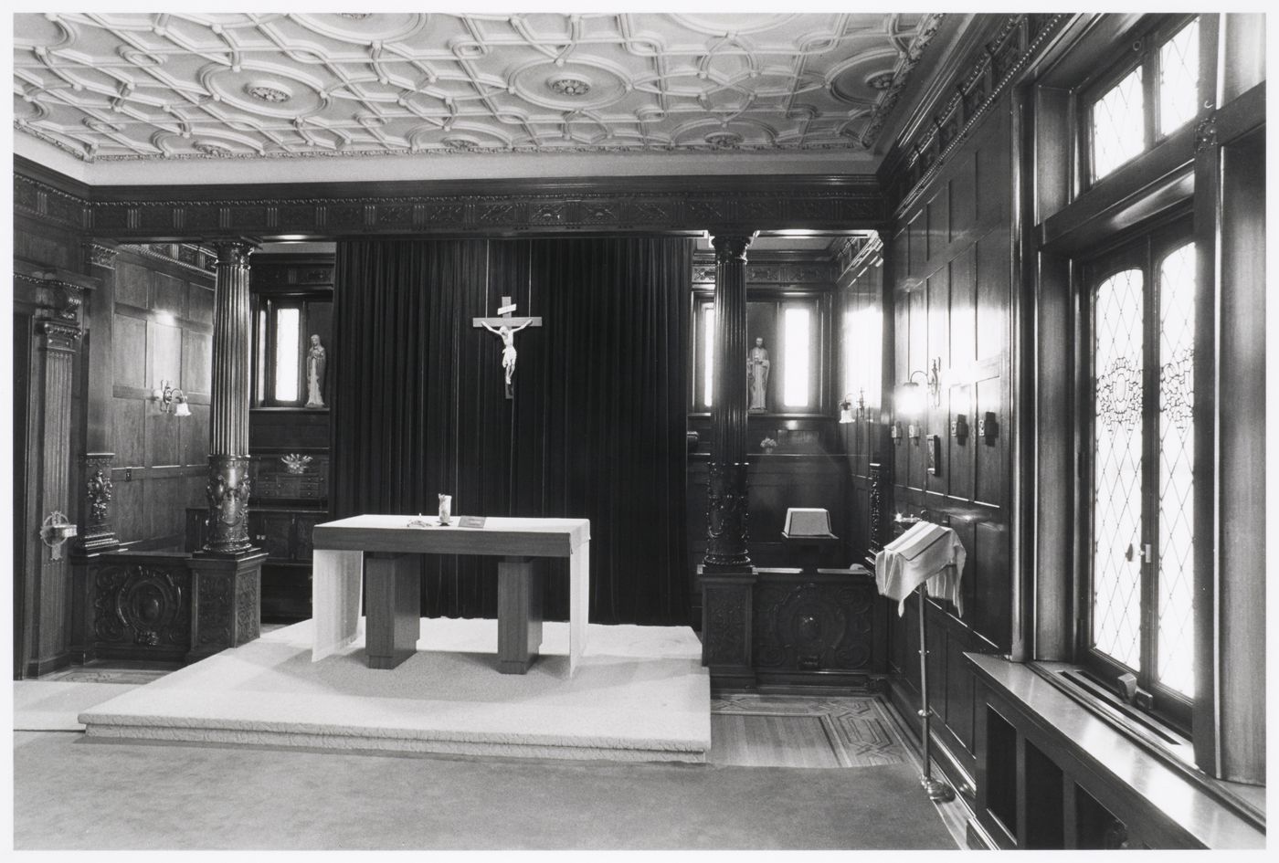 Interior view of the library (now demolished) in the east part of Shaughnessy House showing an altar and a crucifix, Montréal, Québec