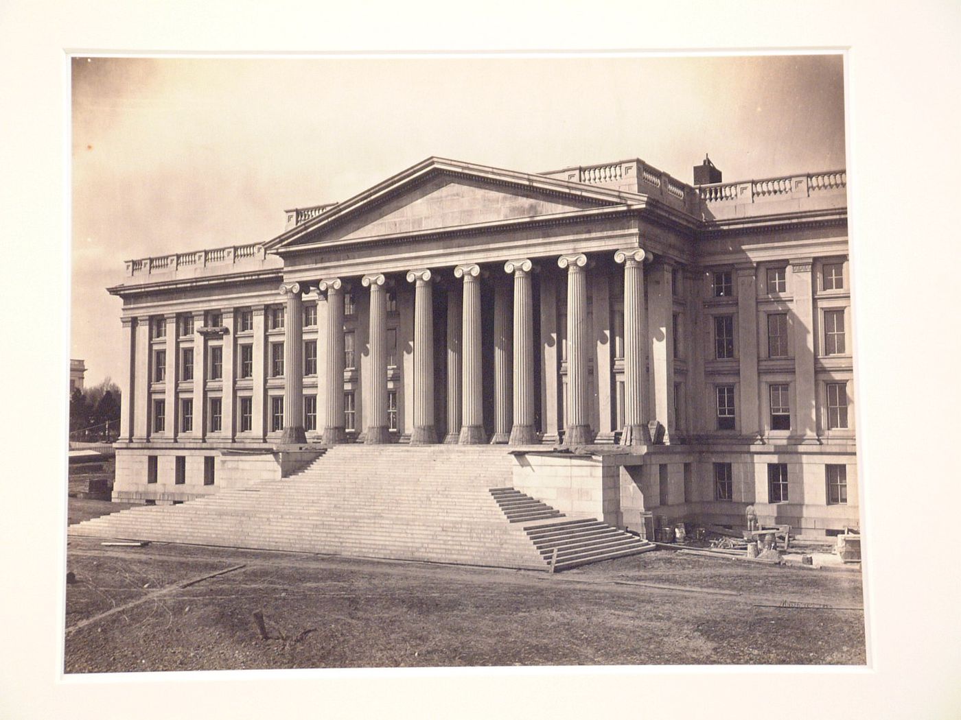 Treasury Building under contruction: Three-quarter view, stairs leading up to columns, workman on right, Washington, District of Columbia