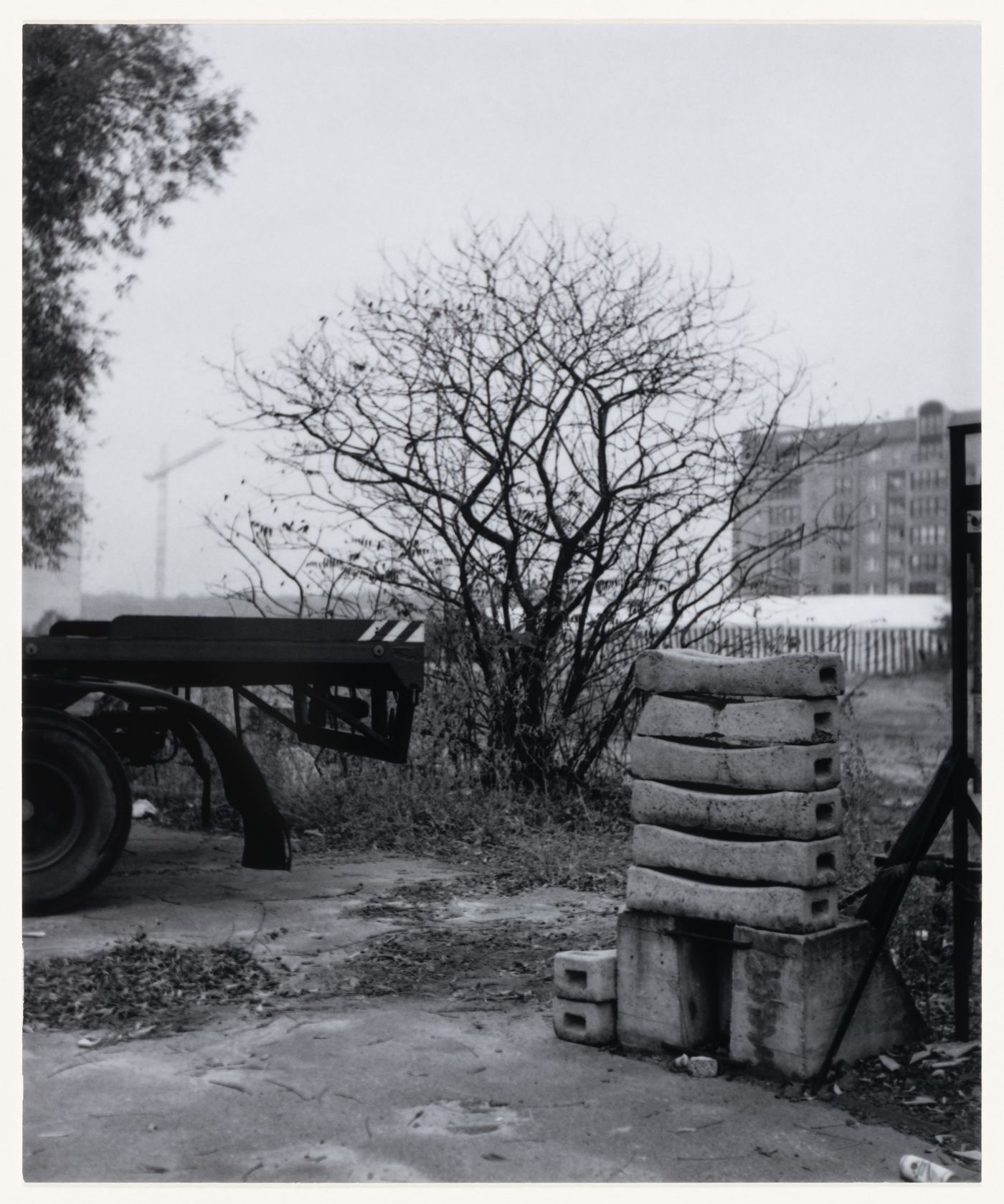 View of building materials, trees and the back of a truck showing a building in the background, Berlin, Germany, from the artist book "The Potsdamer Project"