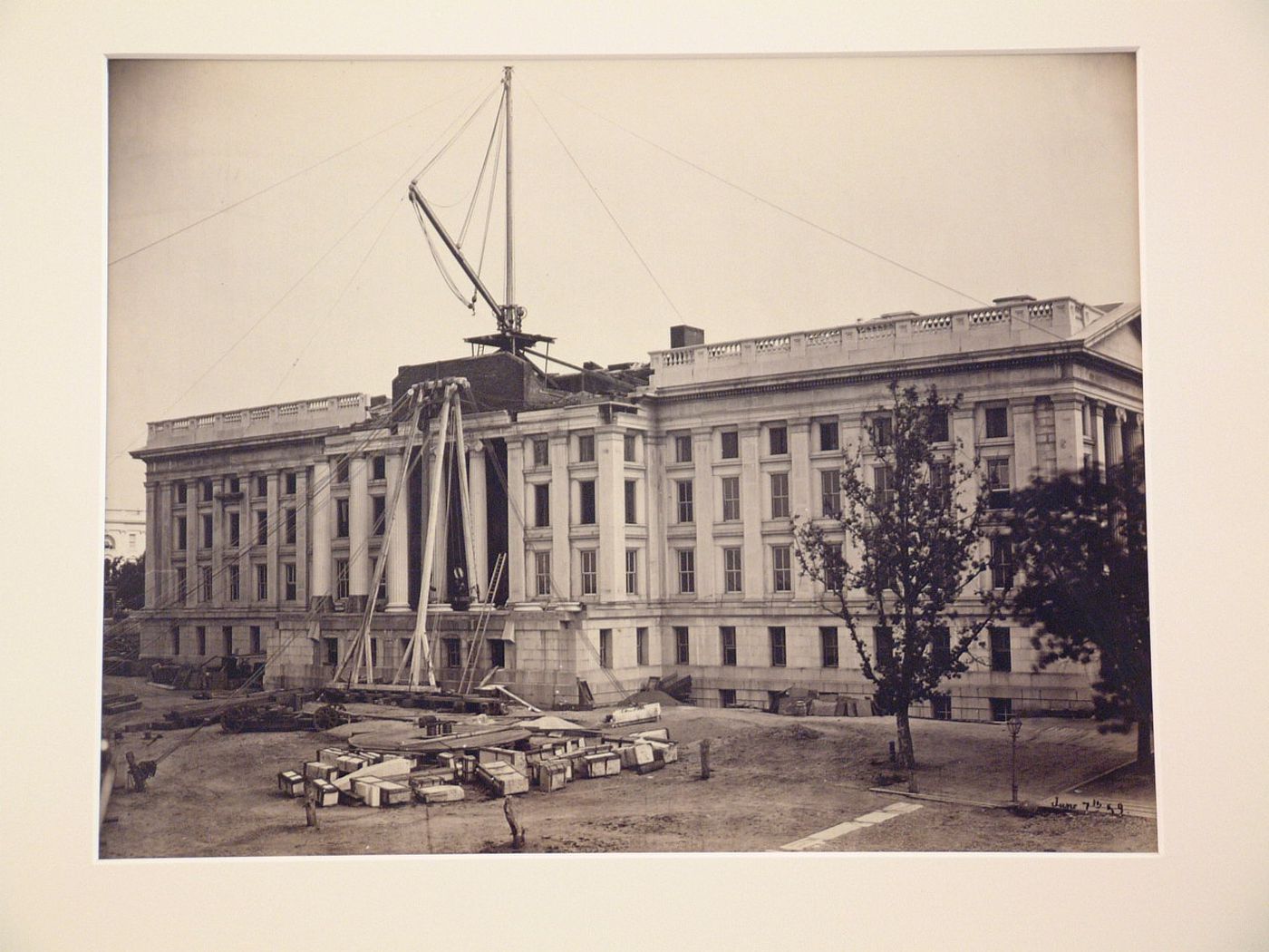 Treasury Building under contruction: Crane on roof and in front of columns, Washington, District of Columbia