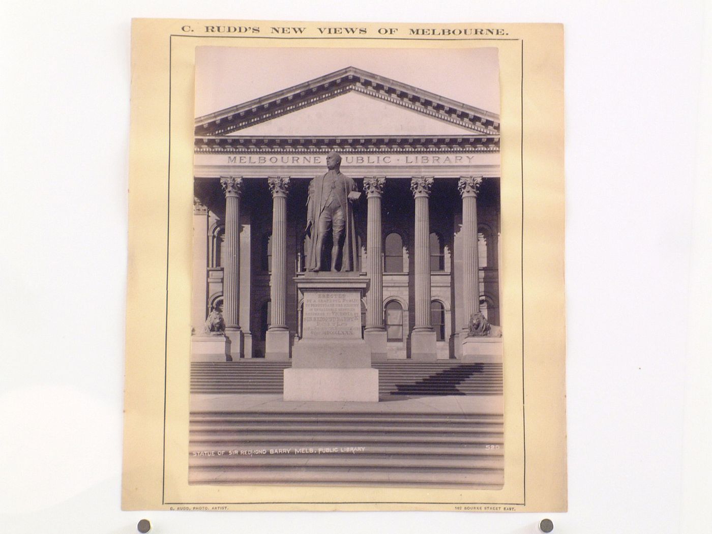 View of the statue of Sir Redmond Barry in front of the principal façade of Melbourne Public Library (now the State Library of Victoria), Australia