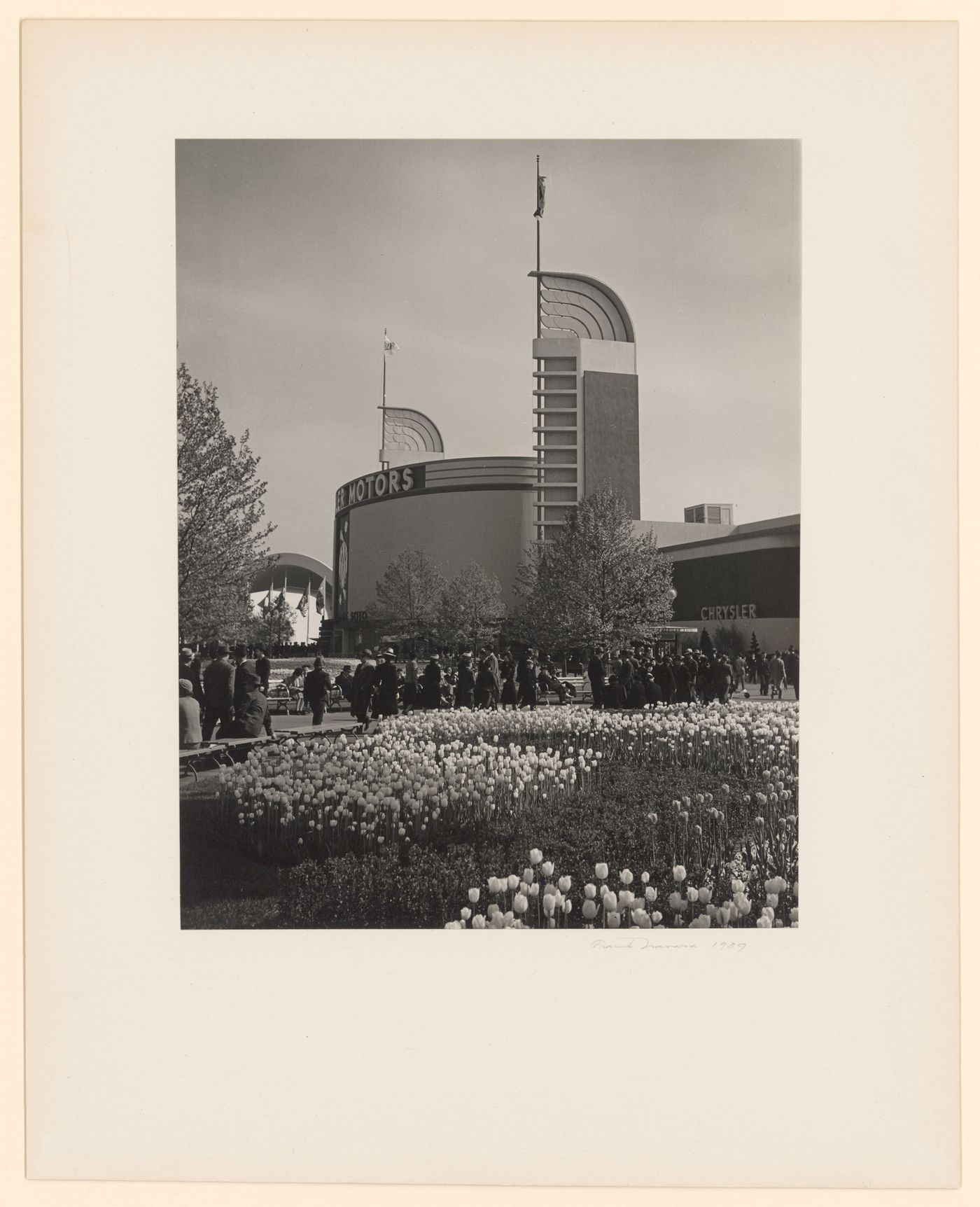 New York World's Fair (1939-1940): View of Chrysler Building, tulip garden and crowds in foreground