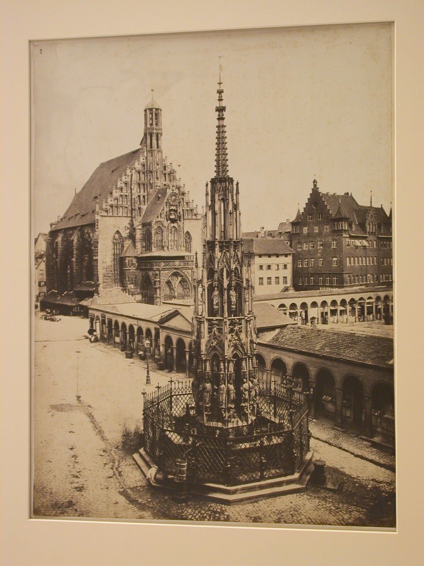 View of Schöner Brunnen foreground and DieLiebfraukirche, with adjacent buildings, including a covered arcade, Nuremberg, Germany