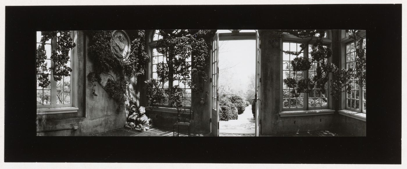 Interior view of the Orangery showing a brick walkway and shrubs through the open door, Dumbarton Oaks, 1703 32nd Street North West, Washington, D.C.