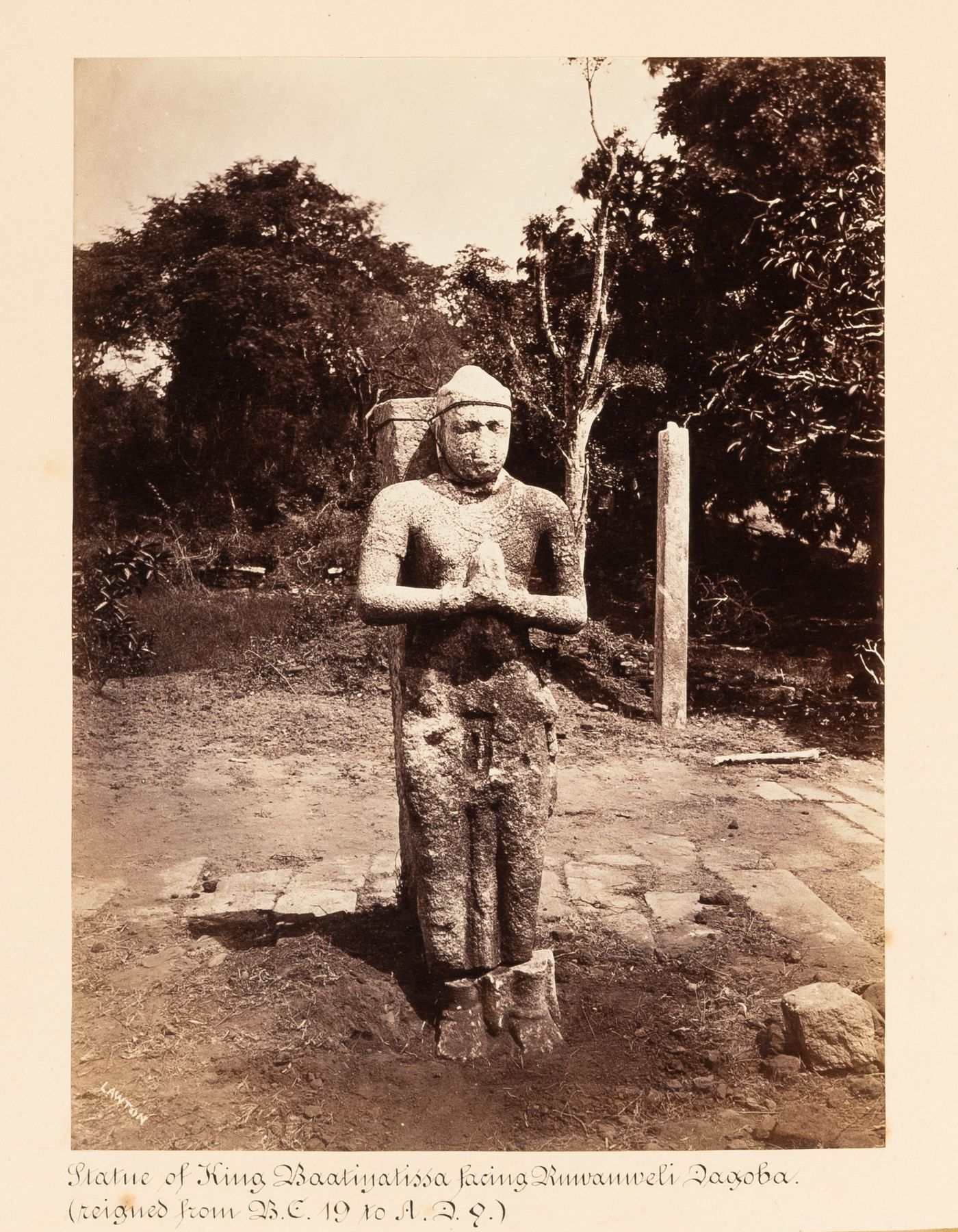 View of a statue of King Baatiyatissa [?], near Ruwanweli Seya (also known as Rumwanweli Dagoba and Rumanweli Maha Seya), Anuradhapura, Ceylon (now Sri Lanka)