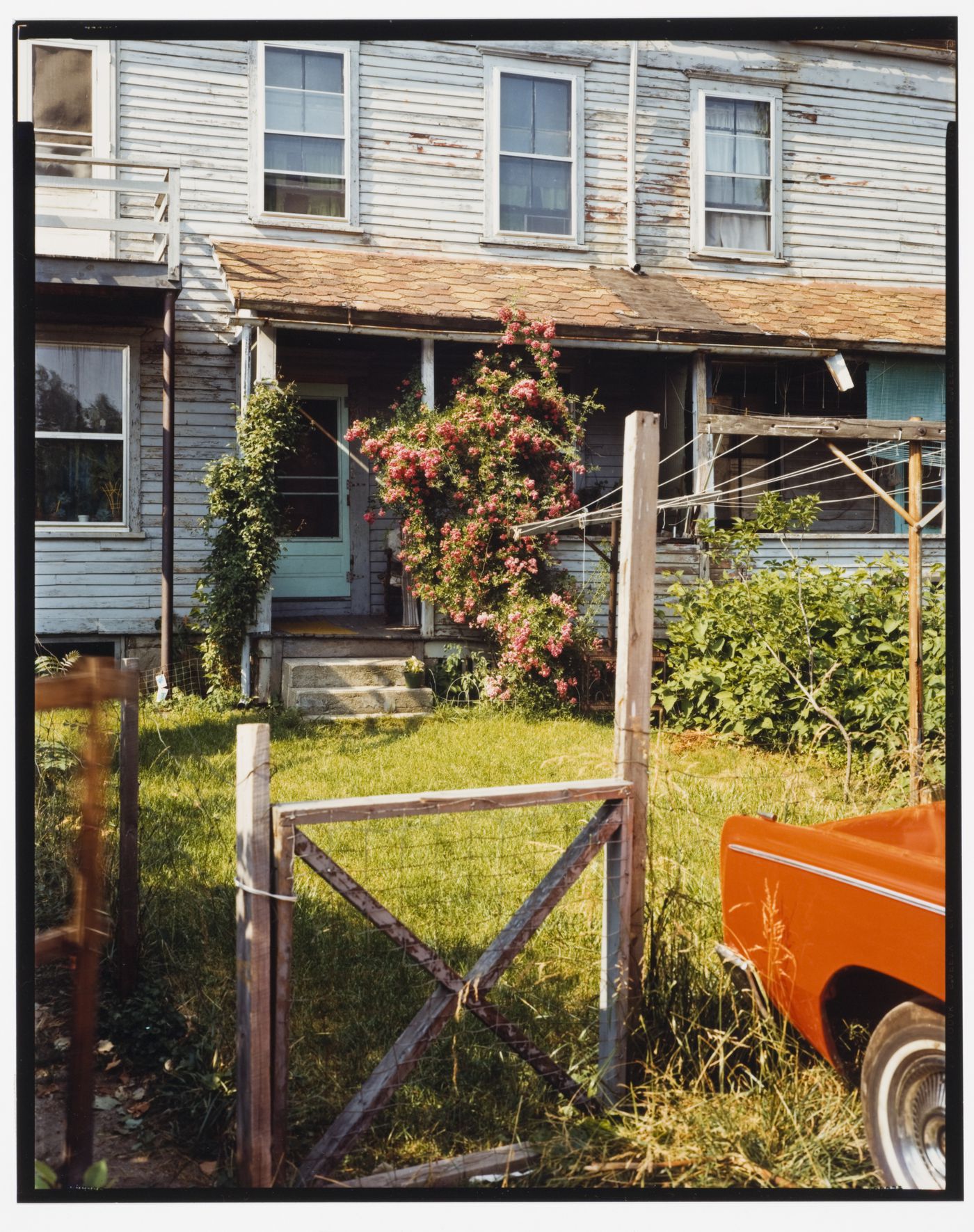 View of houses, grass and the front corner of a red car, Washington Ave., North Adams, Massachusetts