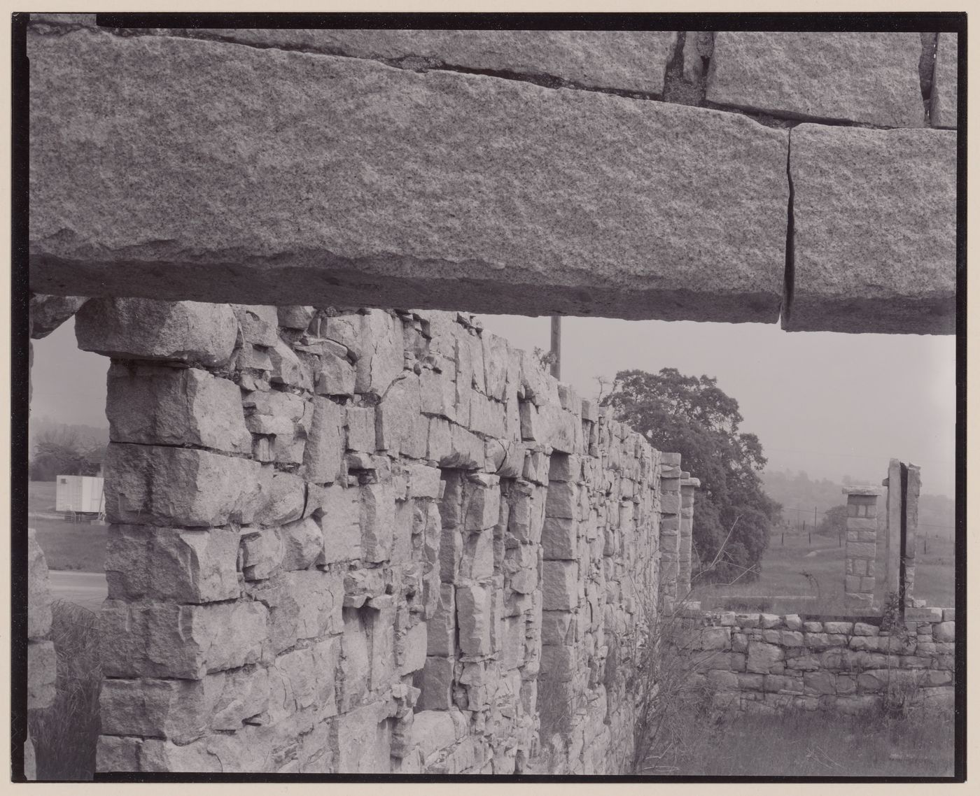 Ruined granite block walls and posts in field, Raymond, California