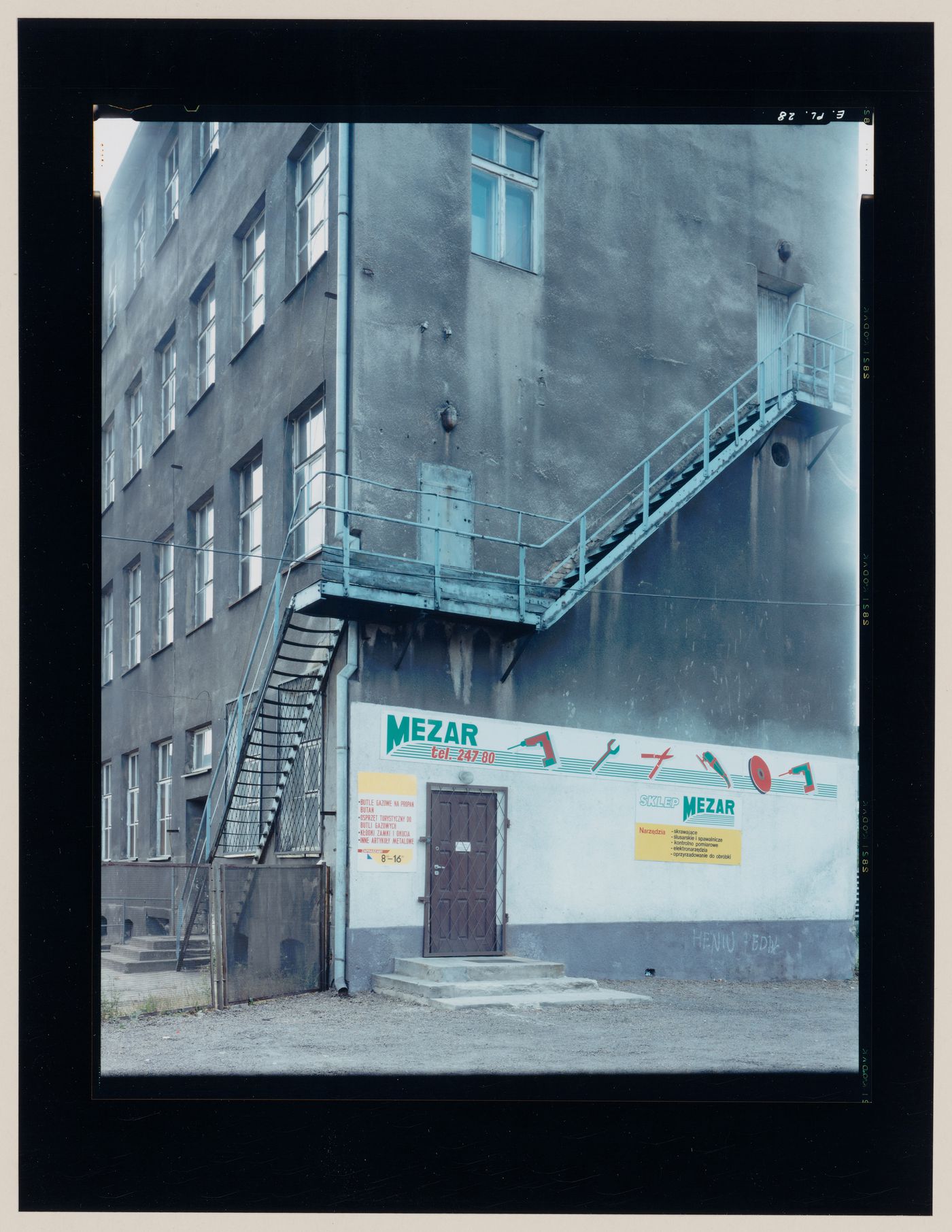 View of a building showing the entrance to a tool store, a sign painted on a wall and a fire escape , Gorzów Wielkopolski, Poland (from the series "In between cities")