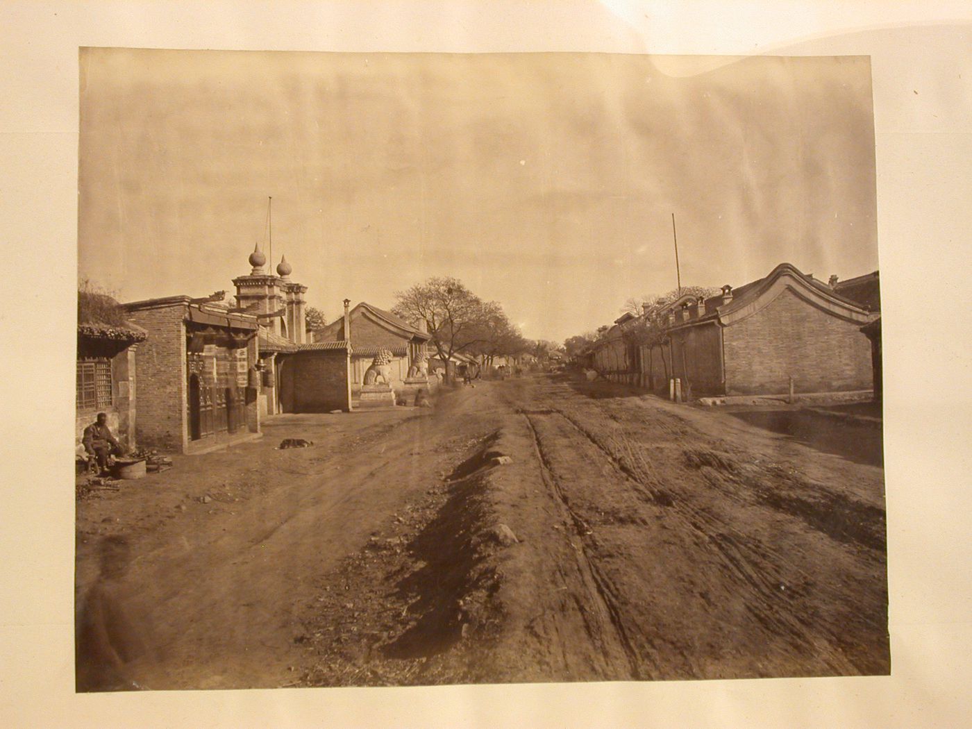View of a road with stores and dwellings on either side, Peking (now Beijing) [?], China