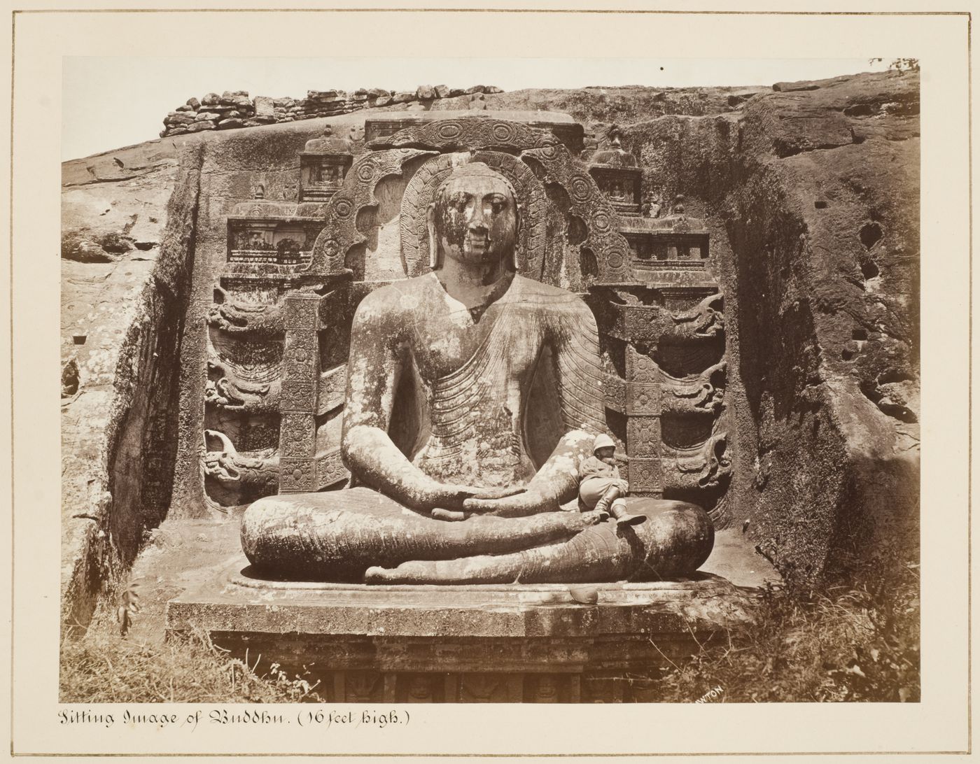 View of a meditating Buddha and a man, Gal Vihara, Polonnaruwa, Ceylon (now Sri Lanka)