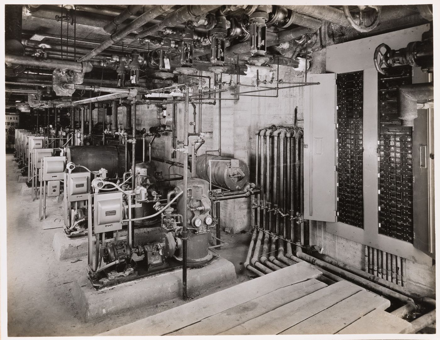 Interior view of the electrical and heating systems, including generators, electric conduits, pumps and boilers, possibly in the main pavilion of Université de Montréal, Montréal [?], Québec