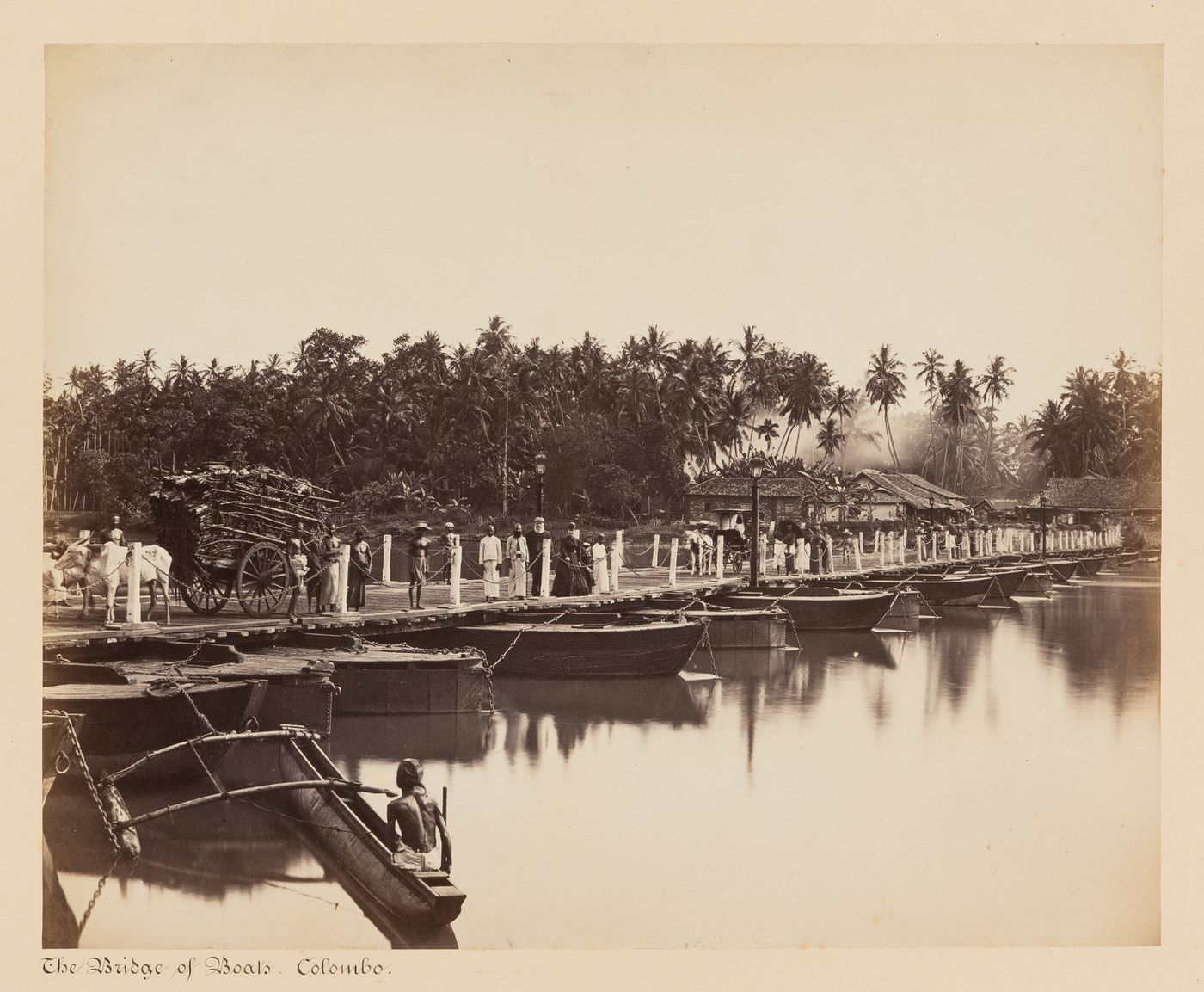 View of the Bridge of Boats and the Kelani Ganga showing people, a carriage and a bullock cart, Colombo, Ceylon (now Sri Lanka)