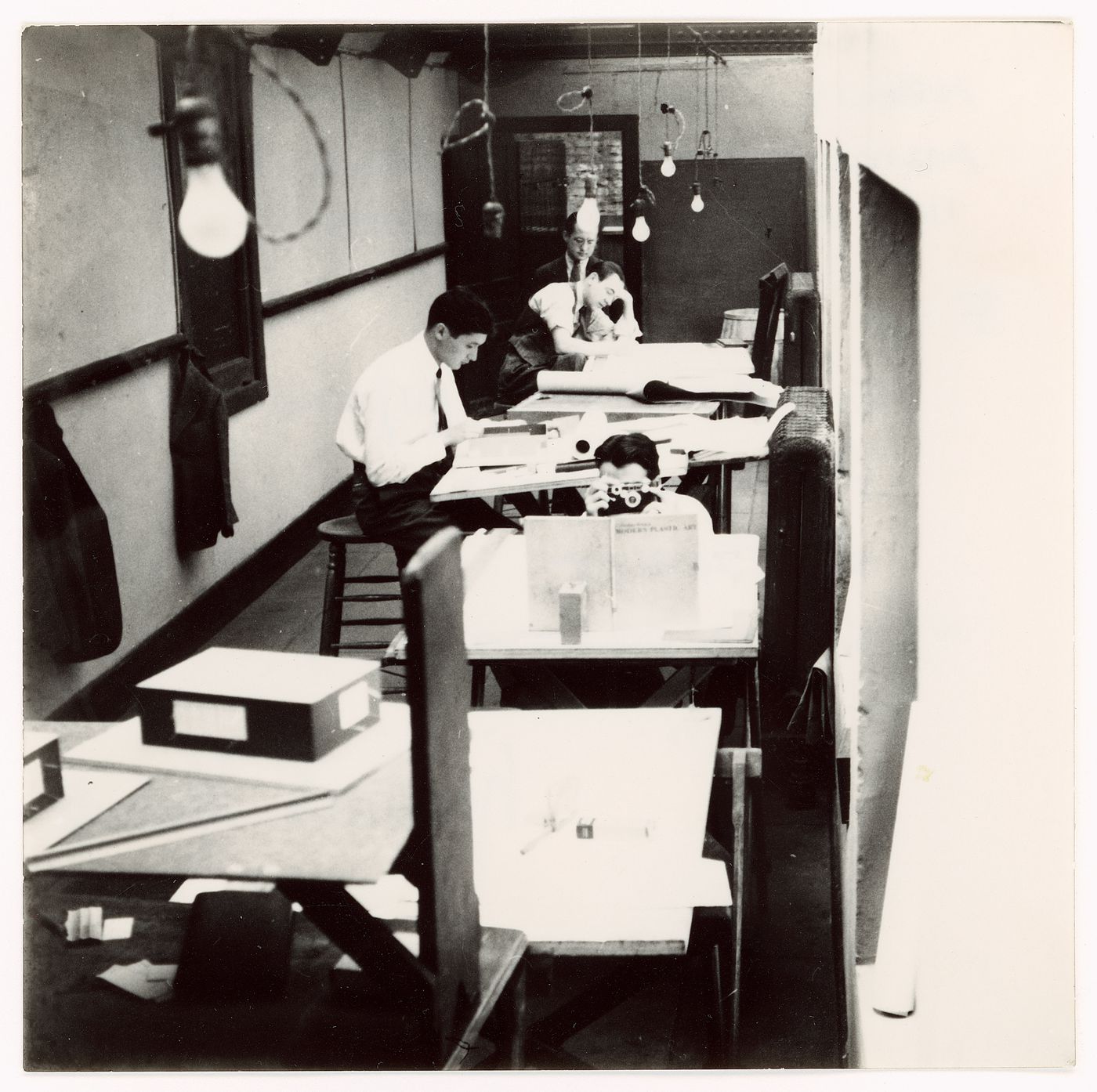 Graduate students (front to back): George Danforth (with camera), Paul Campagna, G. Scott, and C. Worley (?) in the Armour Institute's drafting rooms at the Art Institute of Chicago