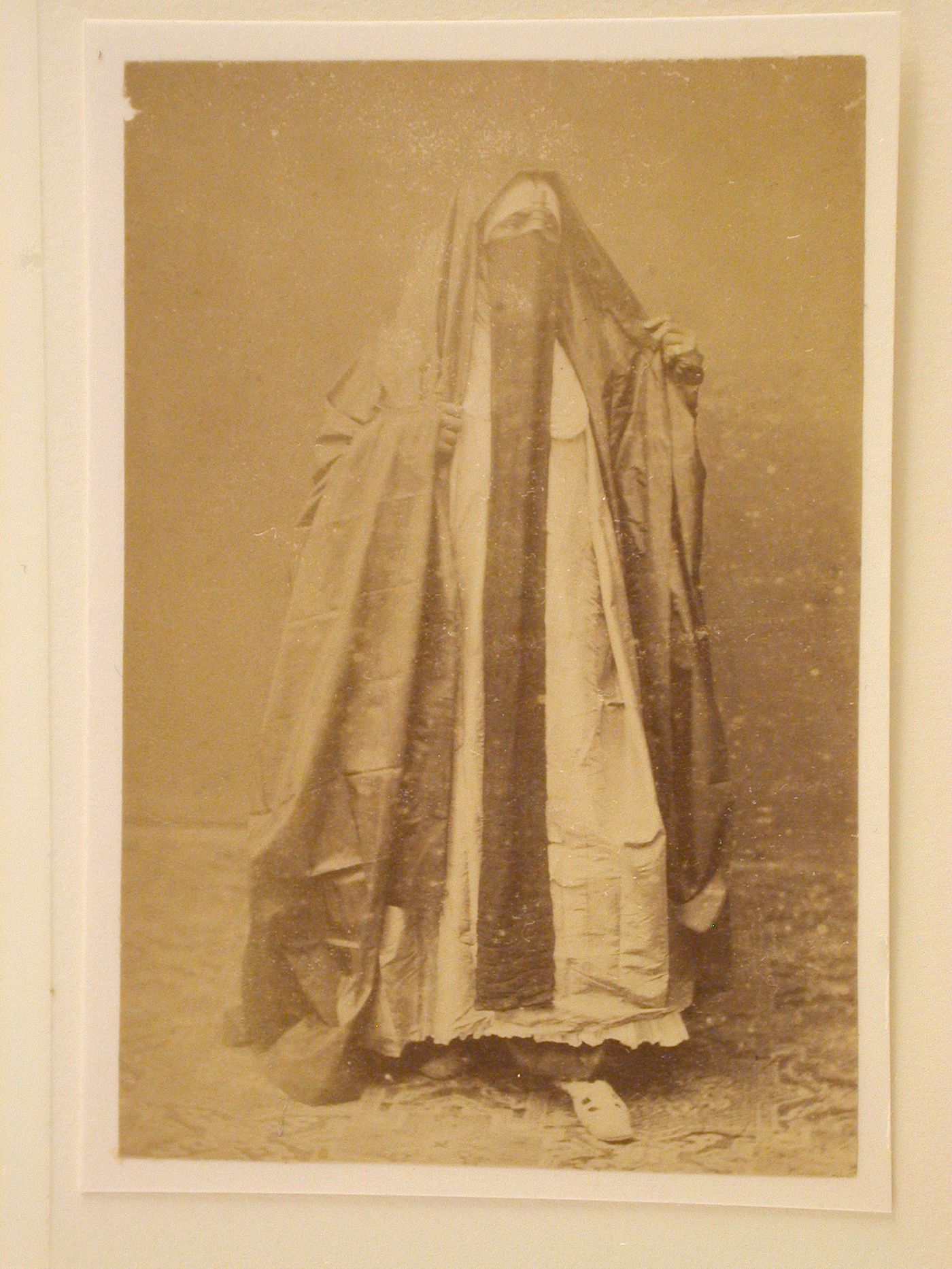 Standing woman dressed in long veil