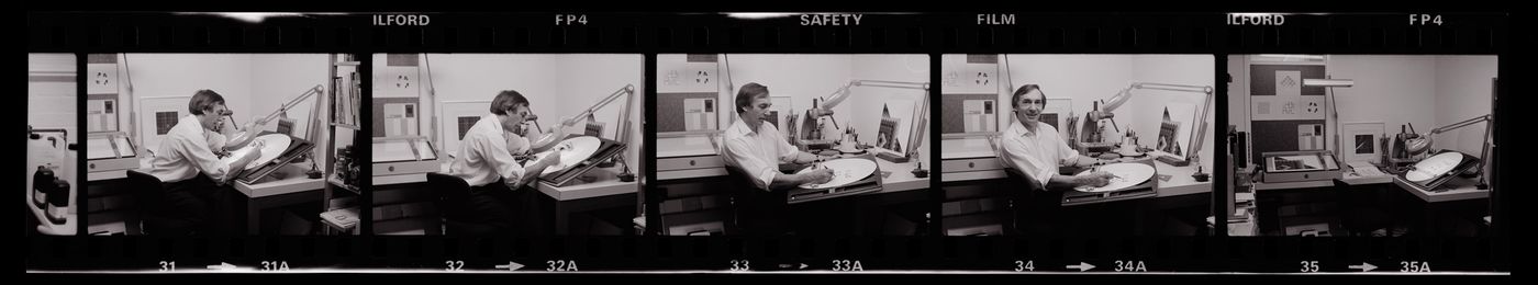 Photographic negatives of Lionel March working at a drafting table