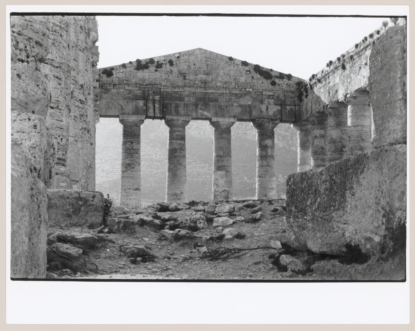 Interior view of the ruins of the Temple of Poseidon showing columns, a pediment and rubble, Segesta, Italy